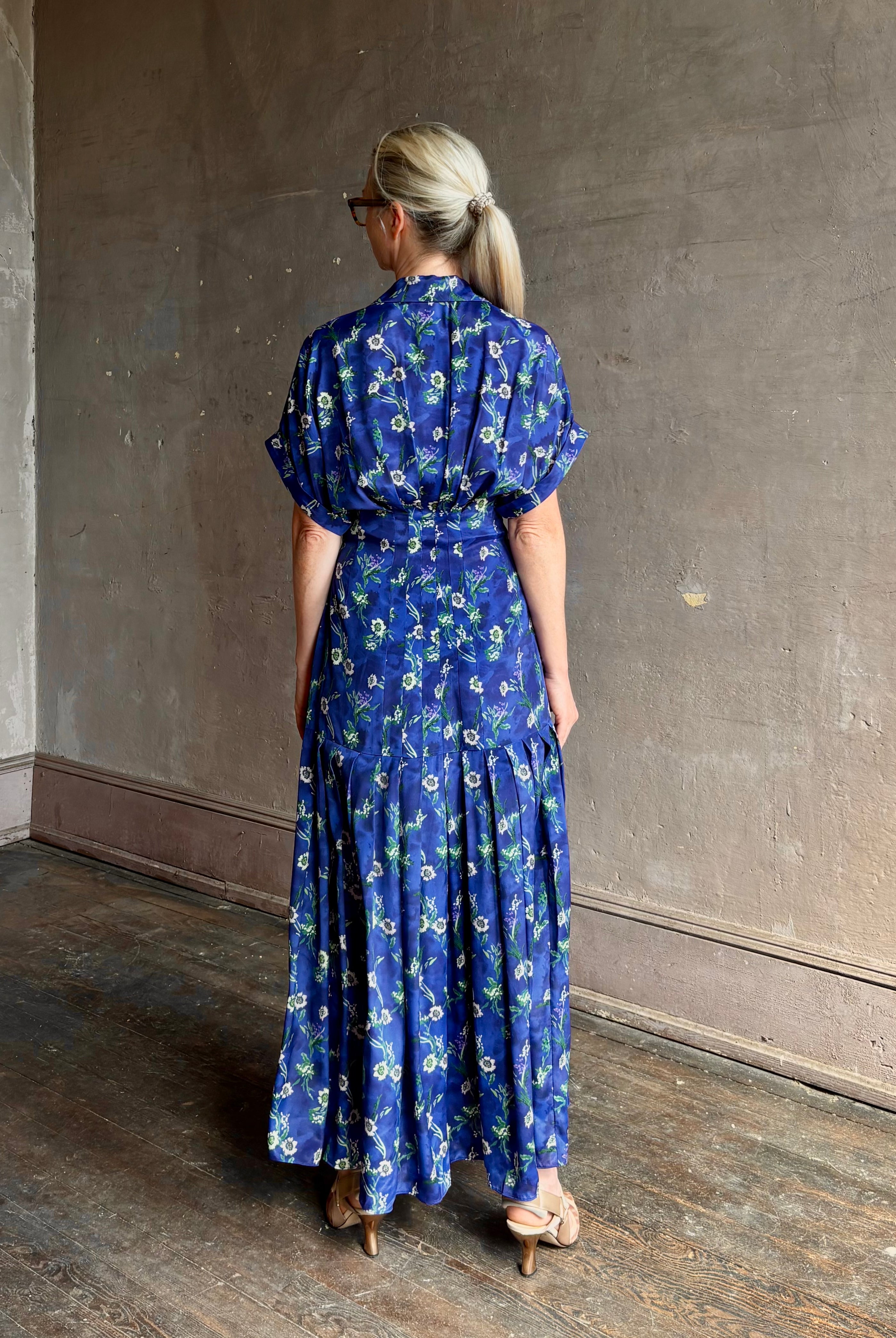 Woman wearing Saloni silk maxi Riya dress with short sleeves bouson top drop waist v-neck button front cobalt