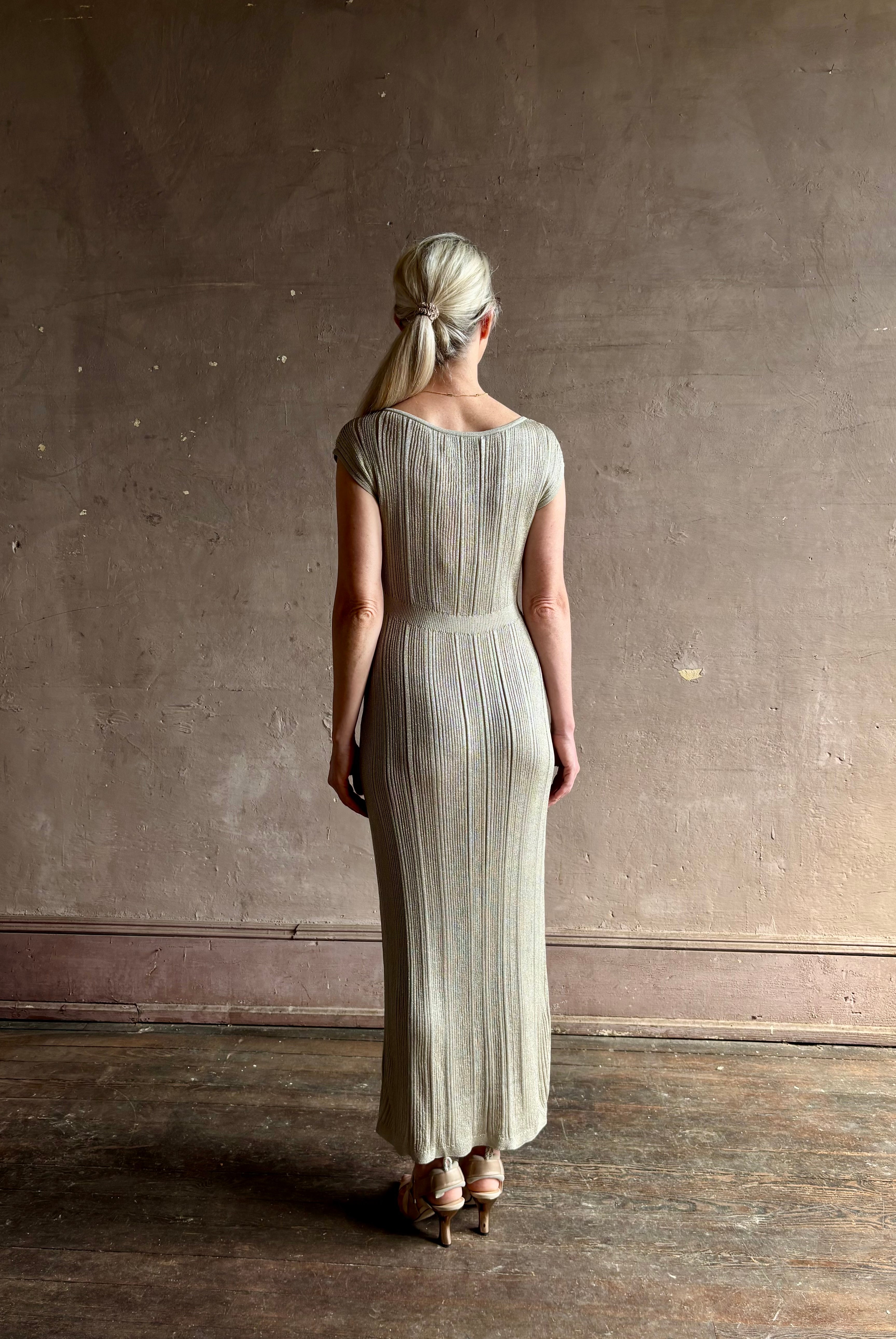 woman wearing saloni stardust cap sleeve floor-length ribbed knit dress front leg vent round neck fitted silver