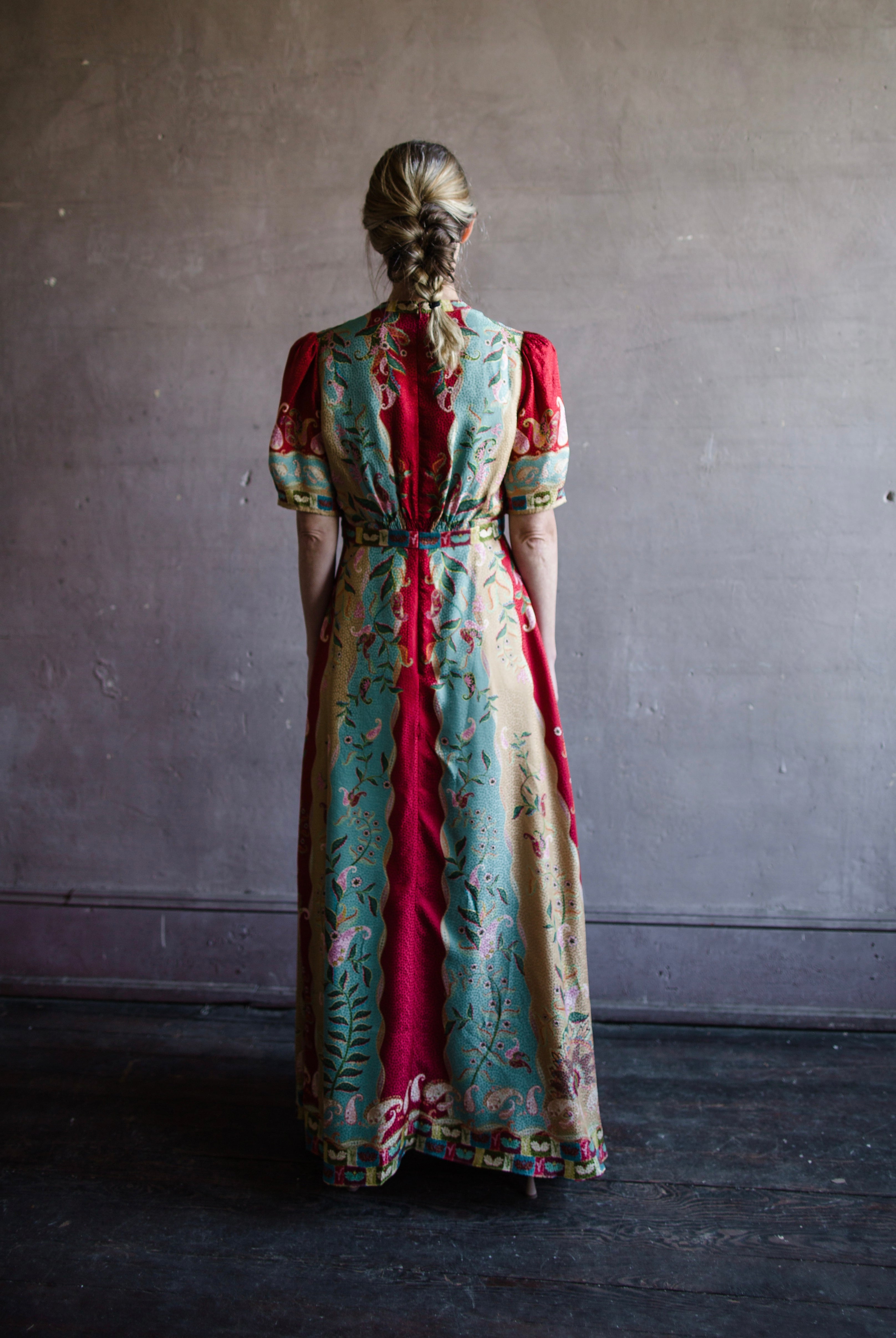 Mature woman wearing Saloni Tabitha silk maxi dress v-neck short sleeves empire waist red yellow aqua floral