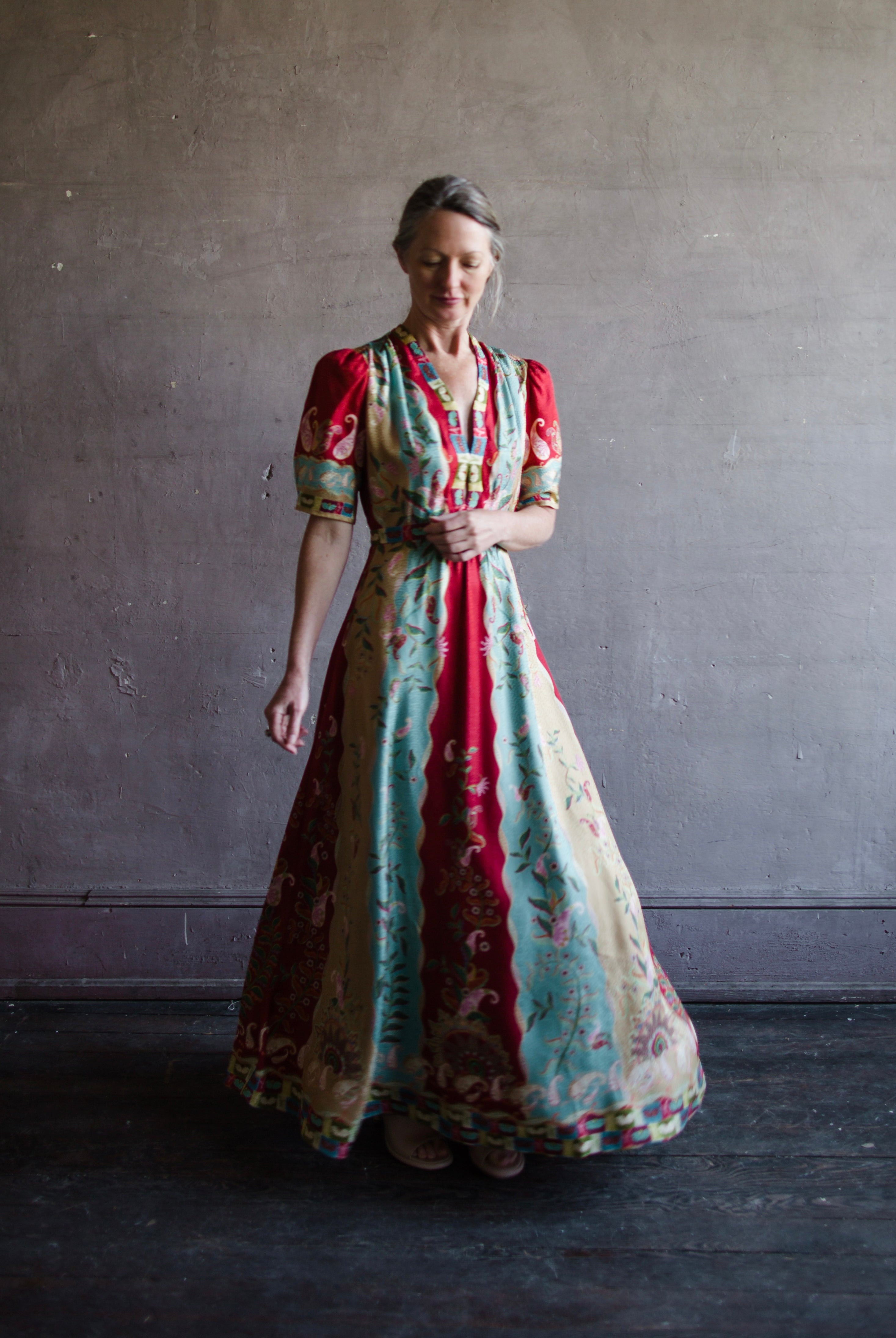 Mature woman wearing Saloni Tabitha silk maxi dress v-neck short sleeves empire waist red yellow aqua floral