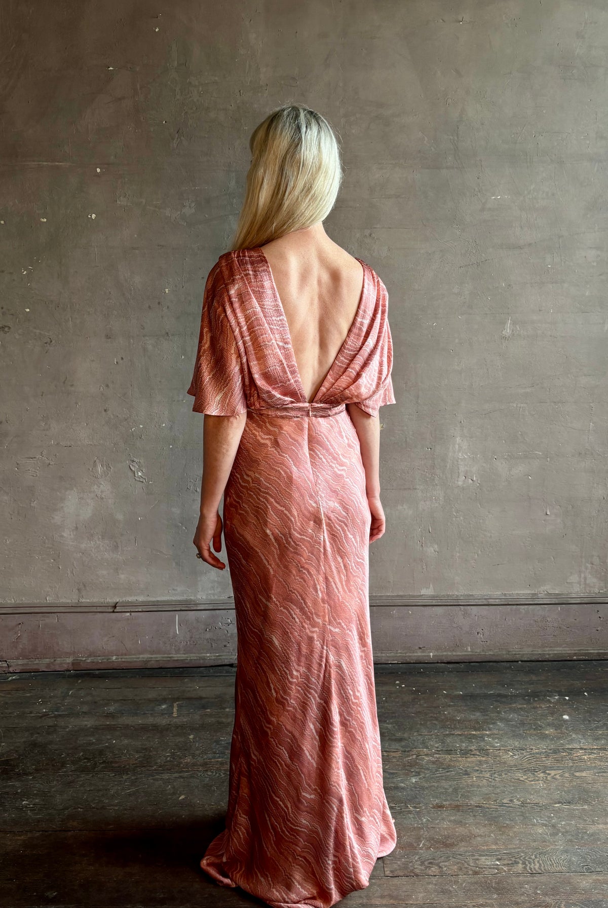 Mature woman wearing Saloni silk Winona Dress in Blush Marbling print V-back detail short sleeves empire waist Romantic occasion gown