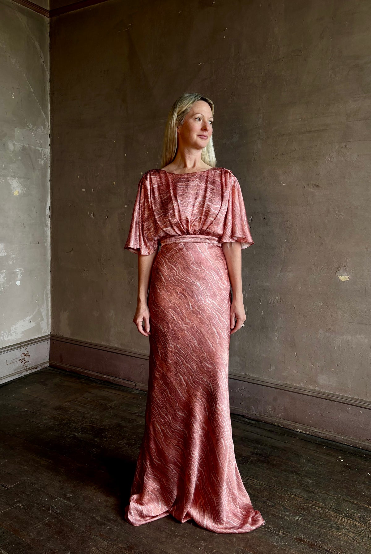 Mature woman wearing Saloni silk Winona Dress in Blush Marbling print V-back detail short sleeves empire waist Romantic occasion gown