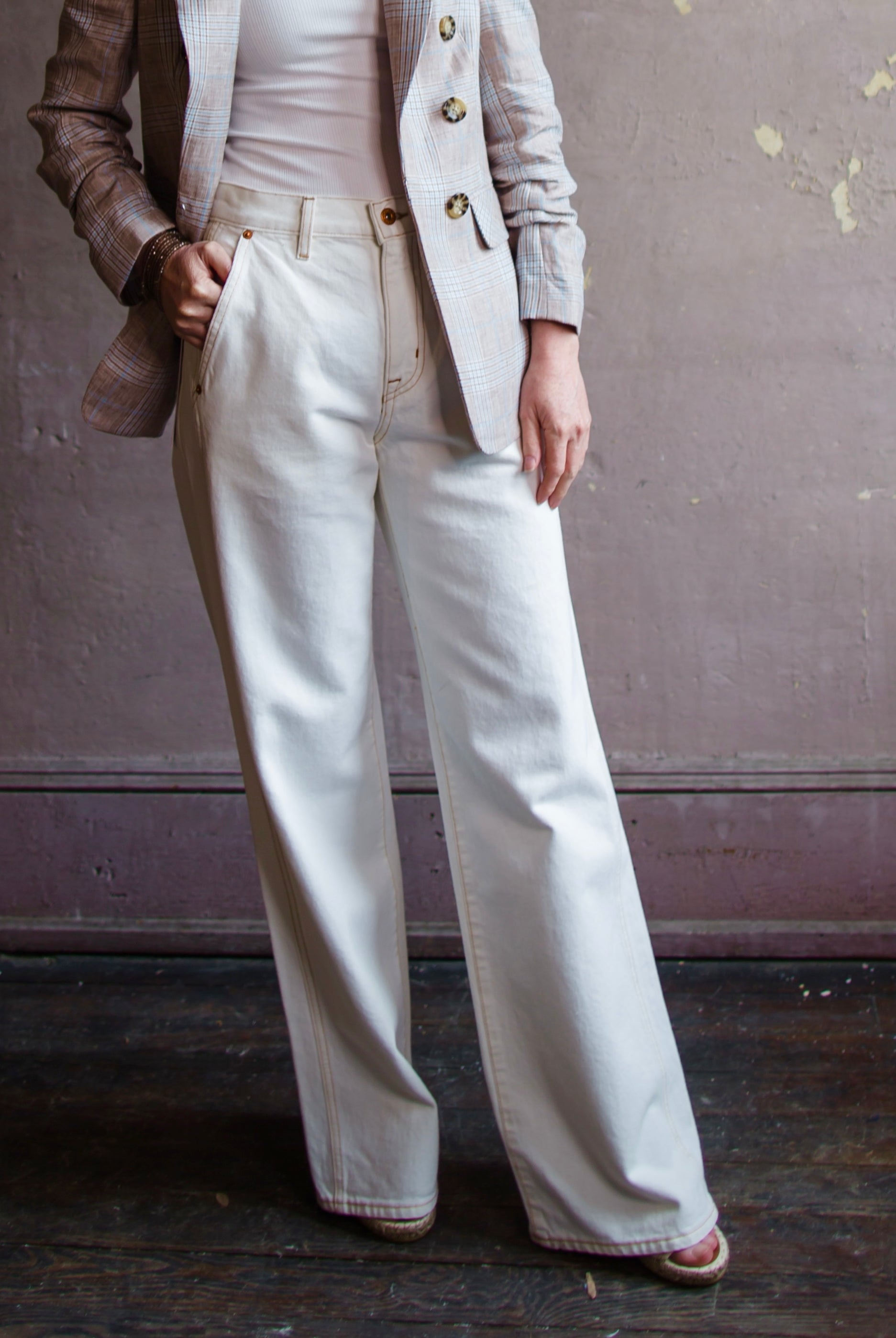 woman wearing Grace Slvrlake cotton rigid denim high-rise, wide leg jeans with a double side seams, slanted side pockets in ecru.