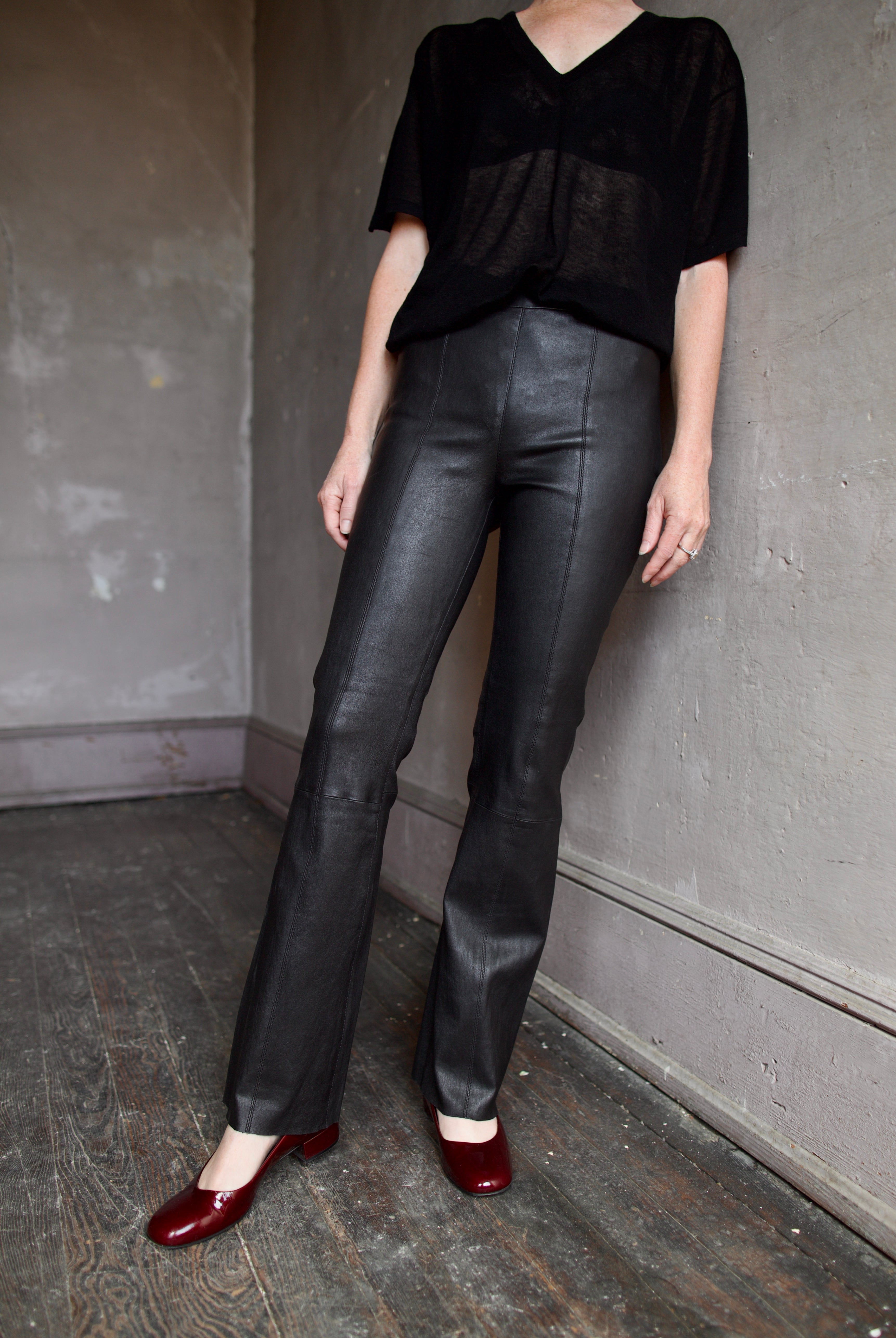 Model wearing SPRWMN Black Ankle Flare Leather Pants - Designer Mid-Rise Stretch Leather