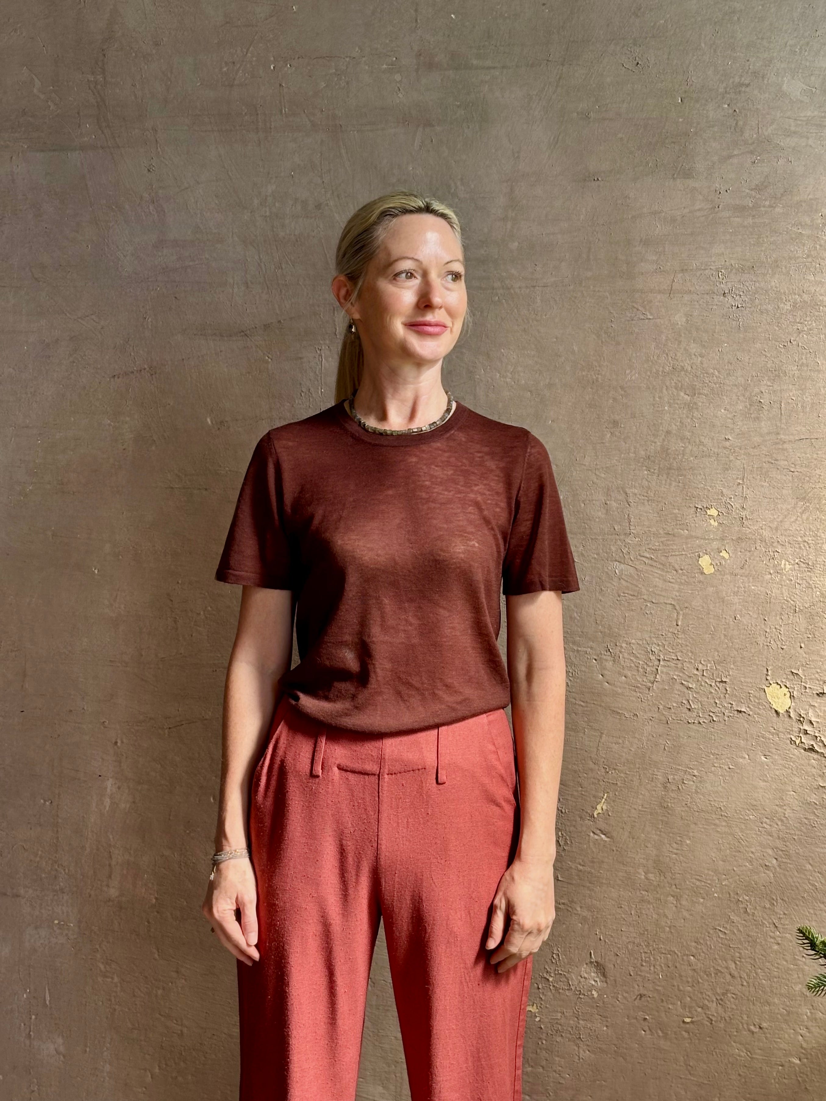 Mature woman wearing premium polished layer SPRWMN classic brown wool tee shirt with crew neck and short sleeves and very light weight for a summer elevated basic or cool weather layering