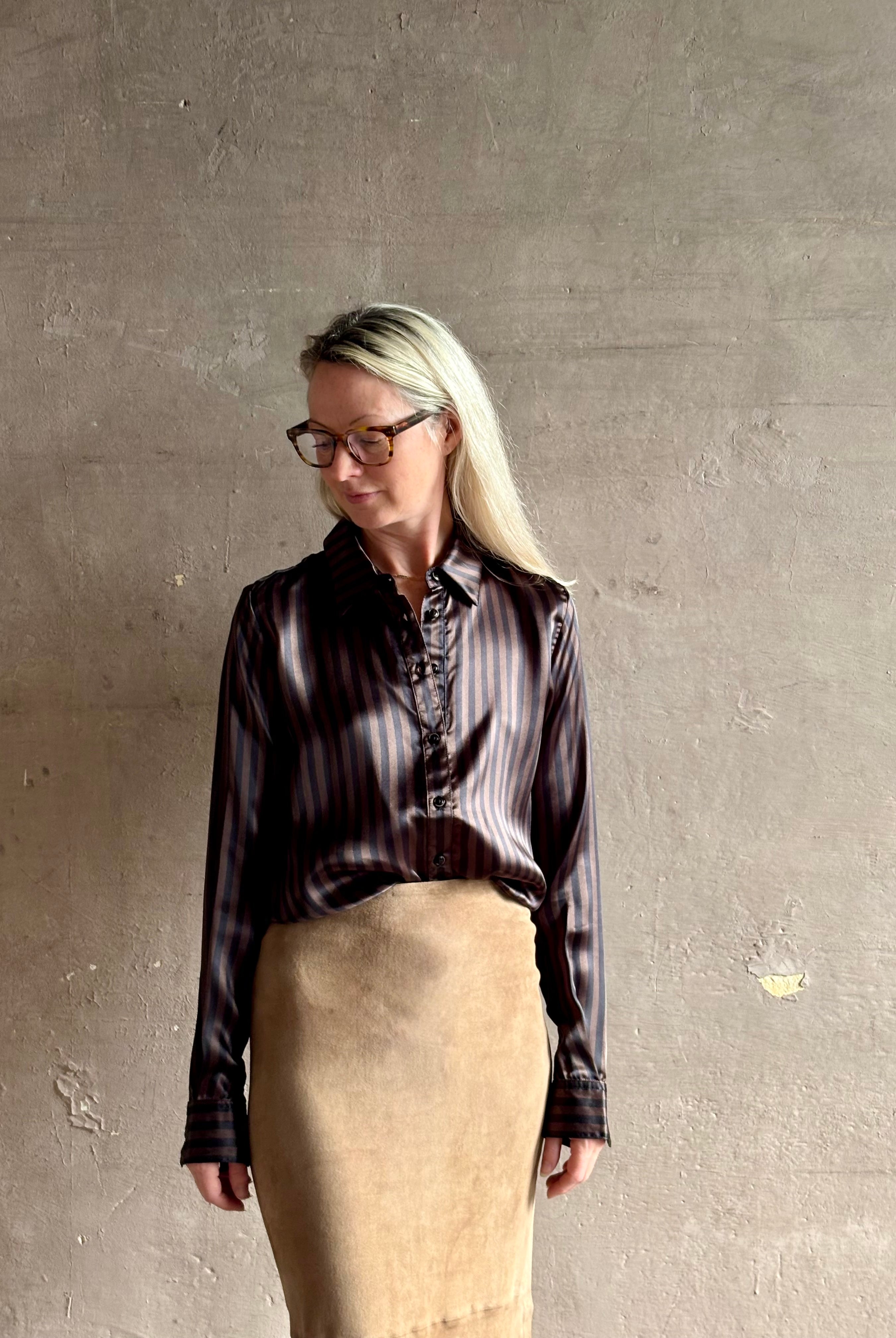 woman wearing luxury brand SPRWMN Fonda silk button up shirt in a black and brown stripe modern classic