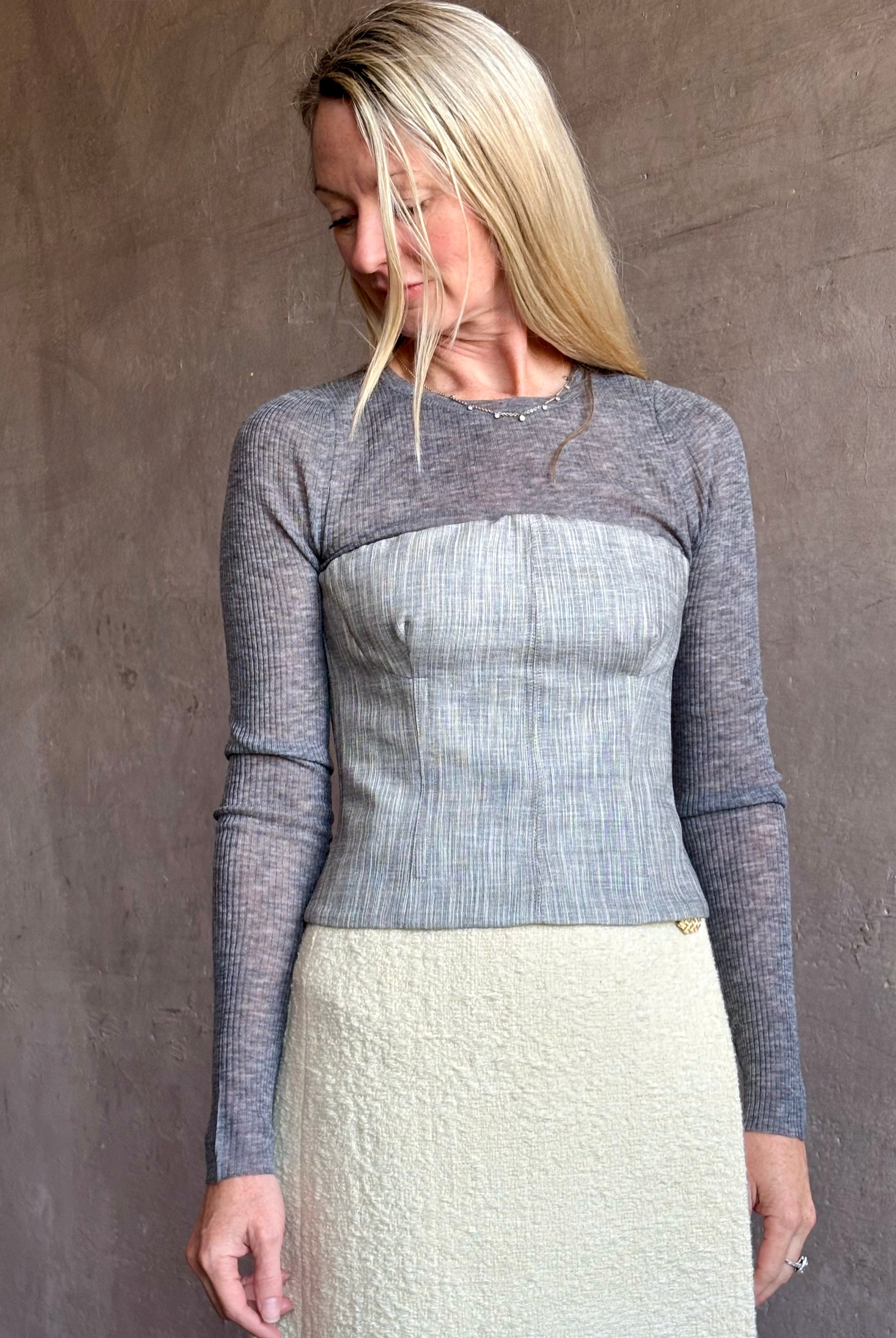 Image of mature woman wearing luxurious SPRWMN long sleeve baby tee with subtle transparency and lightweight knit perfect for layering
