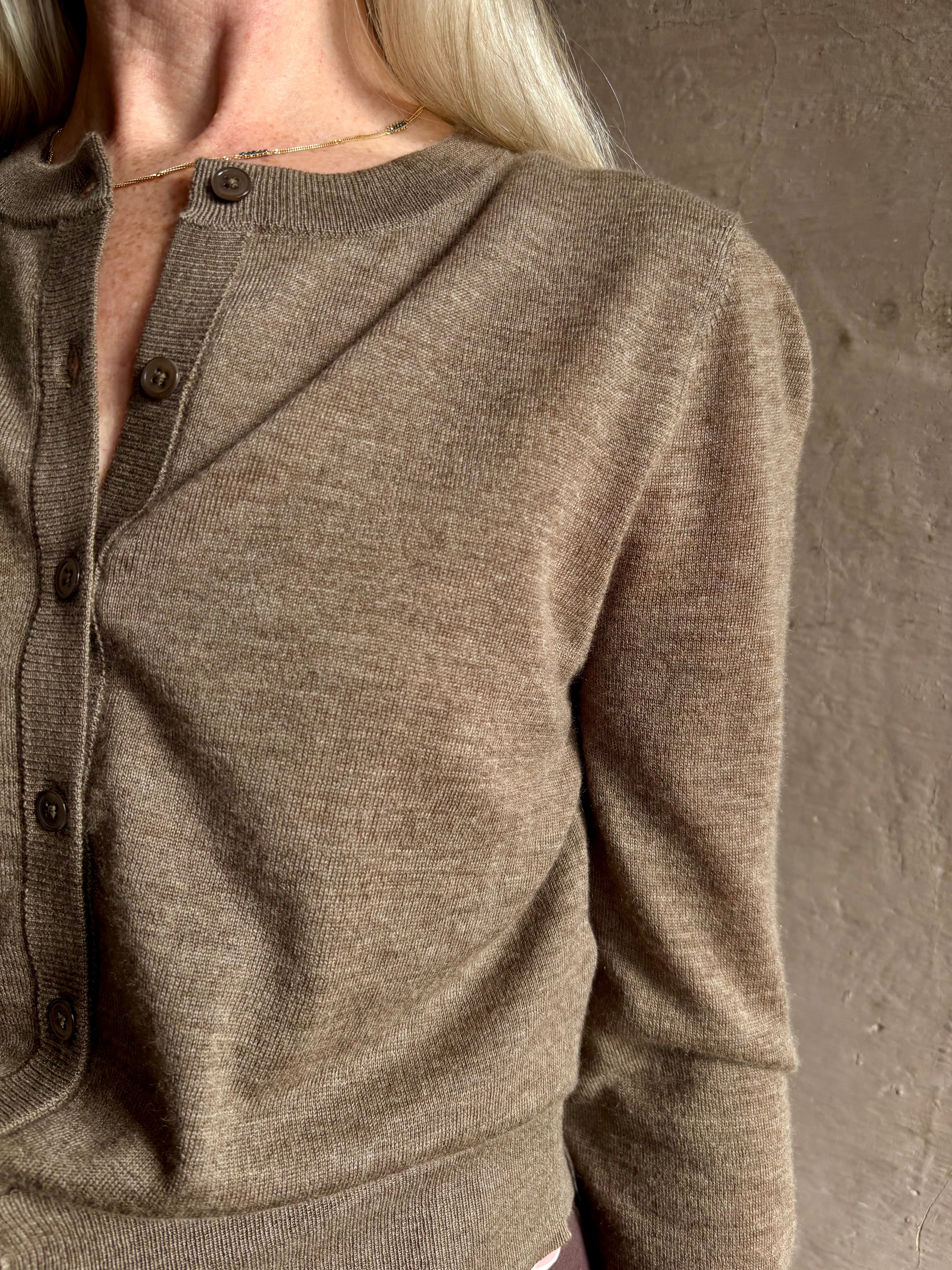 Mature woman wearing designer SPRWMN brown knit cashmere button front layering or stand alone baby cardigan