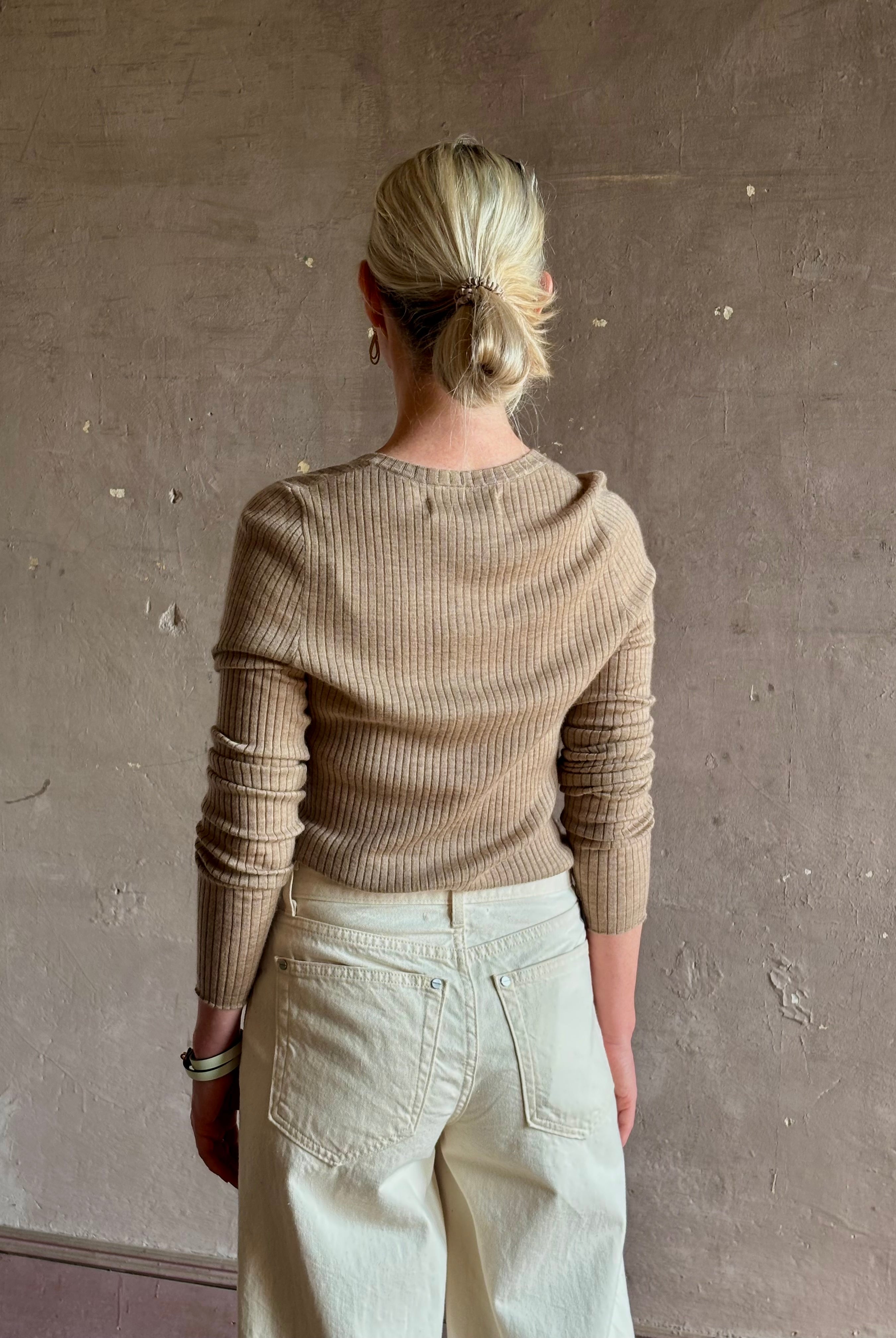 Mature woman wearing SPRWMN beige ribbed round neck cashmere henley top with long sleeves elevated casual wear