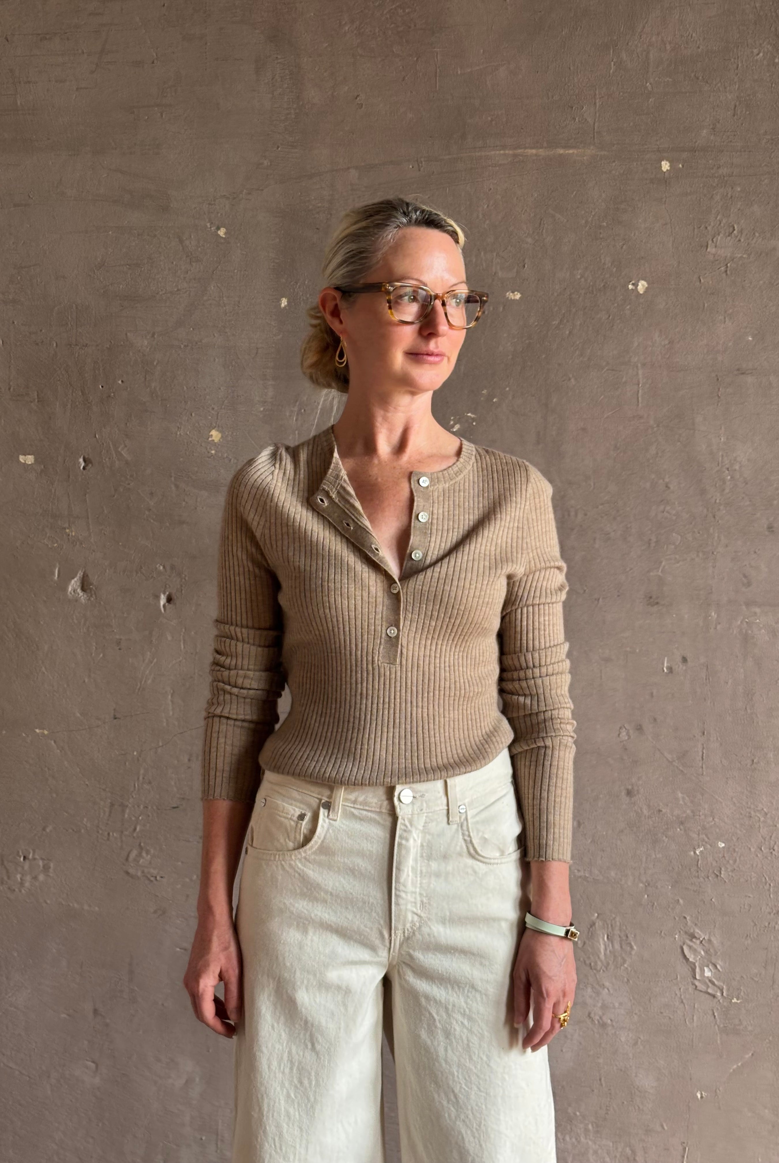 Mature woman wearing SPRWMN beige ribbed round neck cashmere henley top with long sleeves elevated casual wear