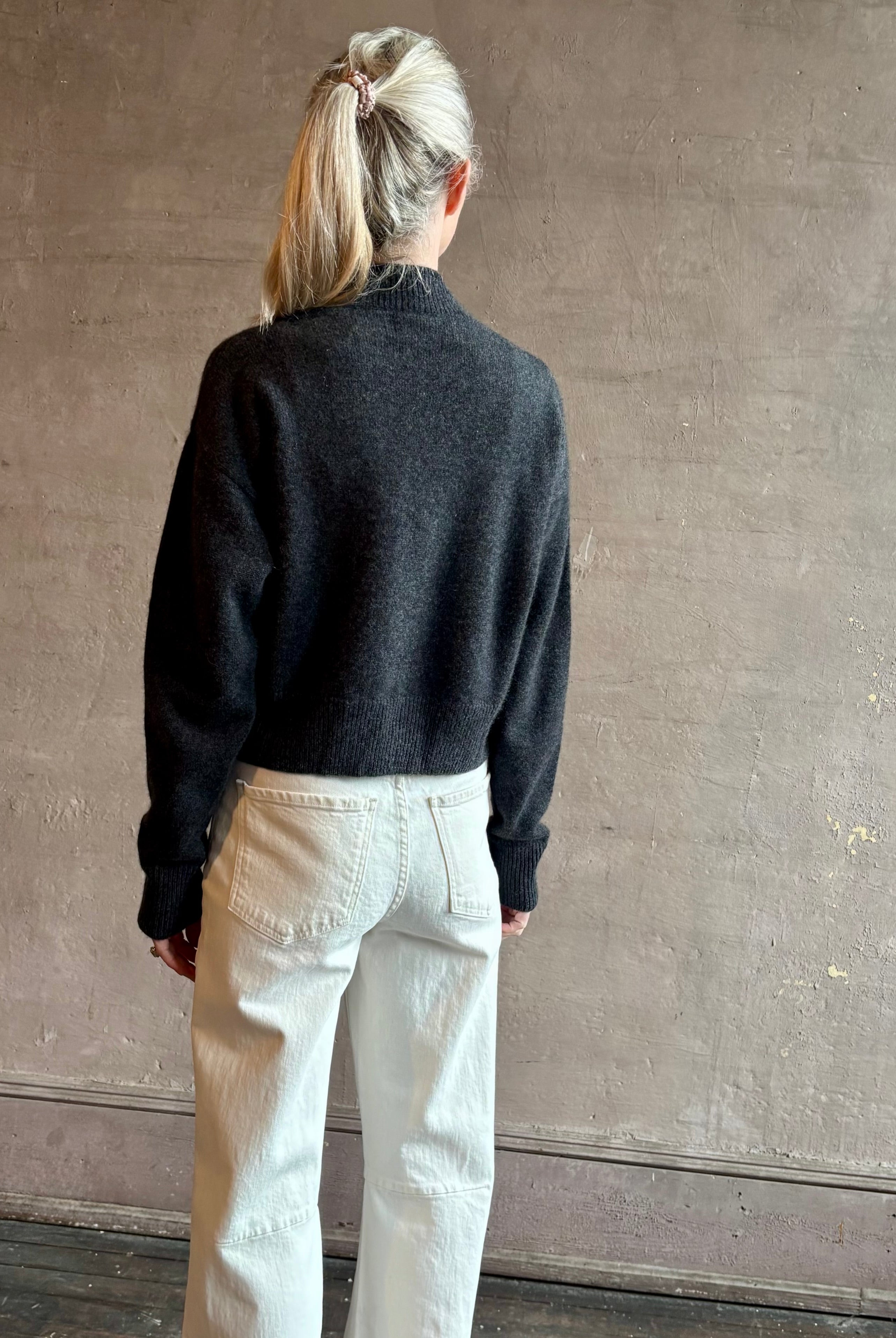 Image of woman wearing luxury women's clothing brand SPRWMN Mia Cardigan in Charcoal Grey with long sleeves