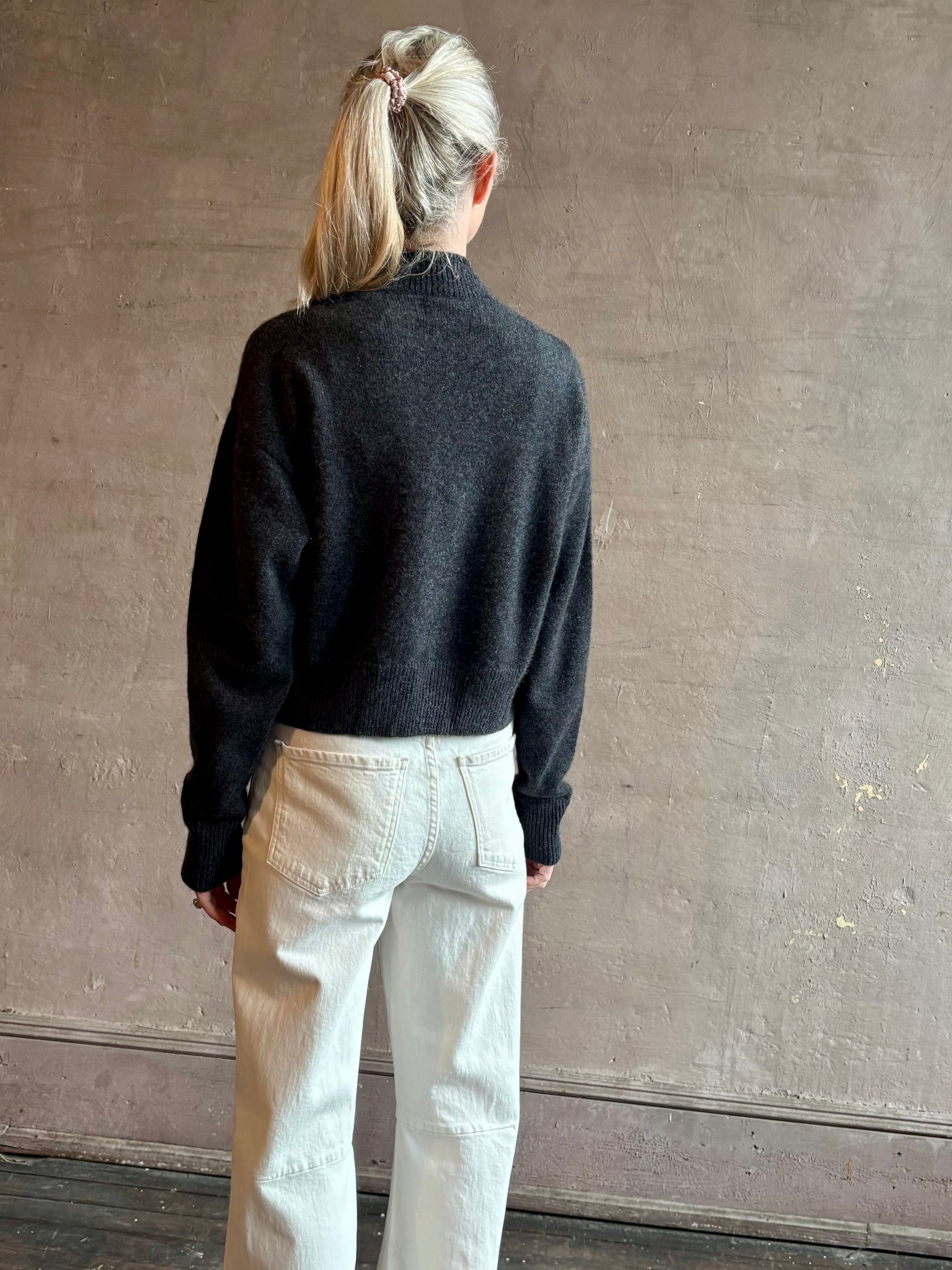 Image of woman wearing luxury women's clothing brand SPRWMN Mia Cardigan in Charcoal Grey with long sleeves