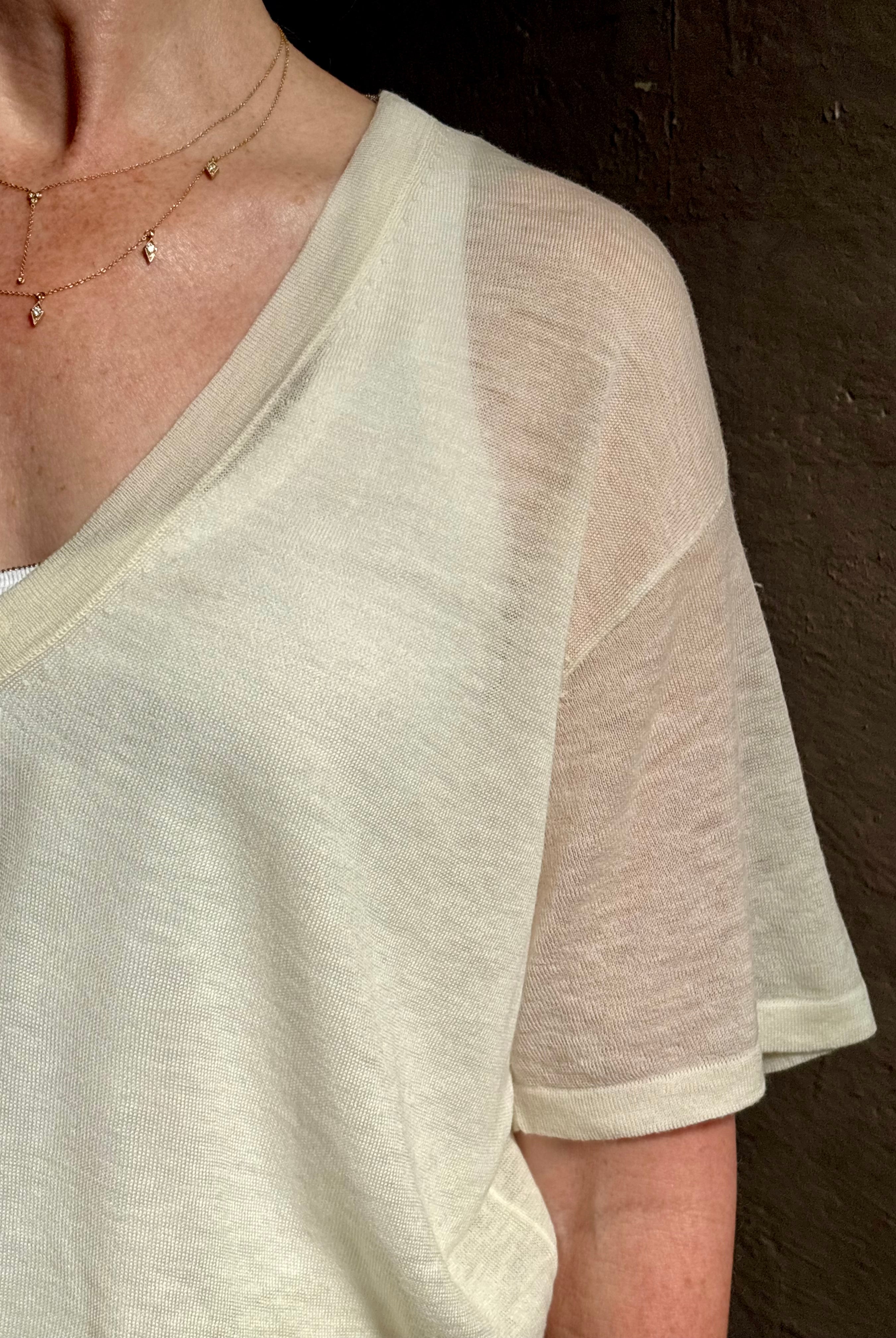 woman wearing SPRWMN lightweight ivory wool sweater short sleeve v-neck in relaxed fit t-shirt design
