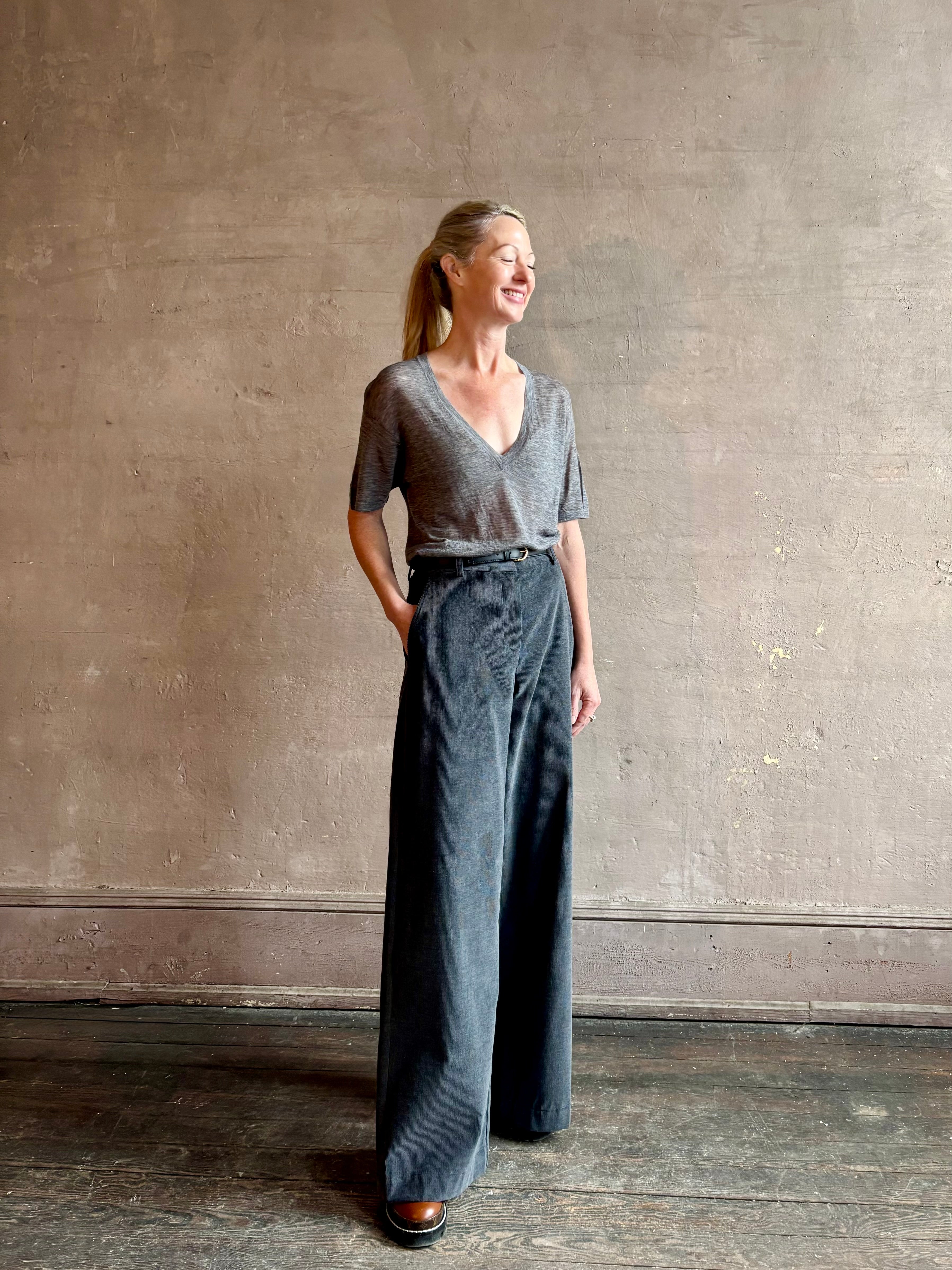 Image of woman wearing premium polished layer SPRWMN grey wool tee shirt with a v-neck and short sleeves