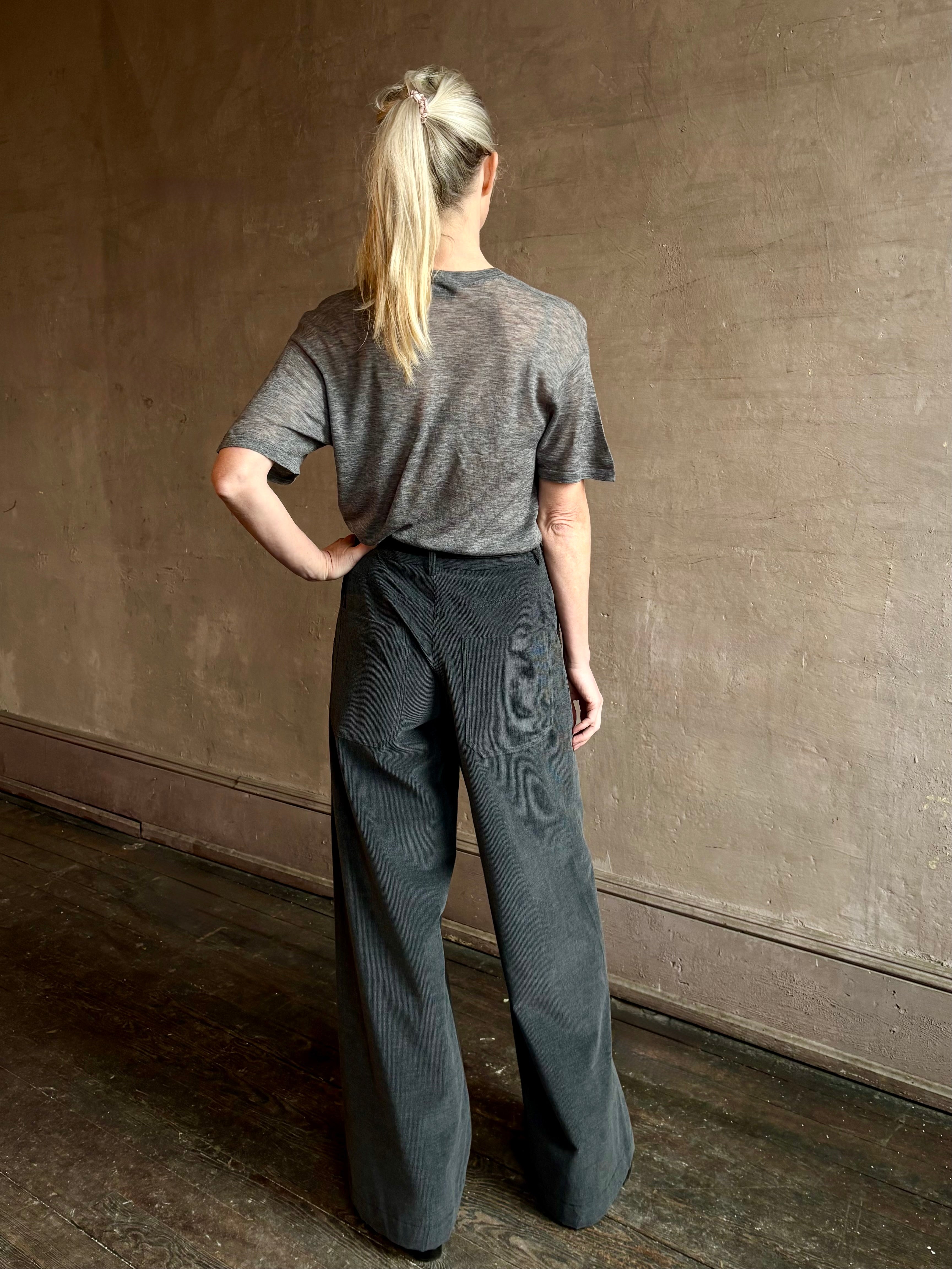 Image of woman wearing premium polished layer SPRWMN grey wool tee shirt with a v-neck and short sleeves