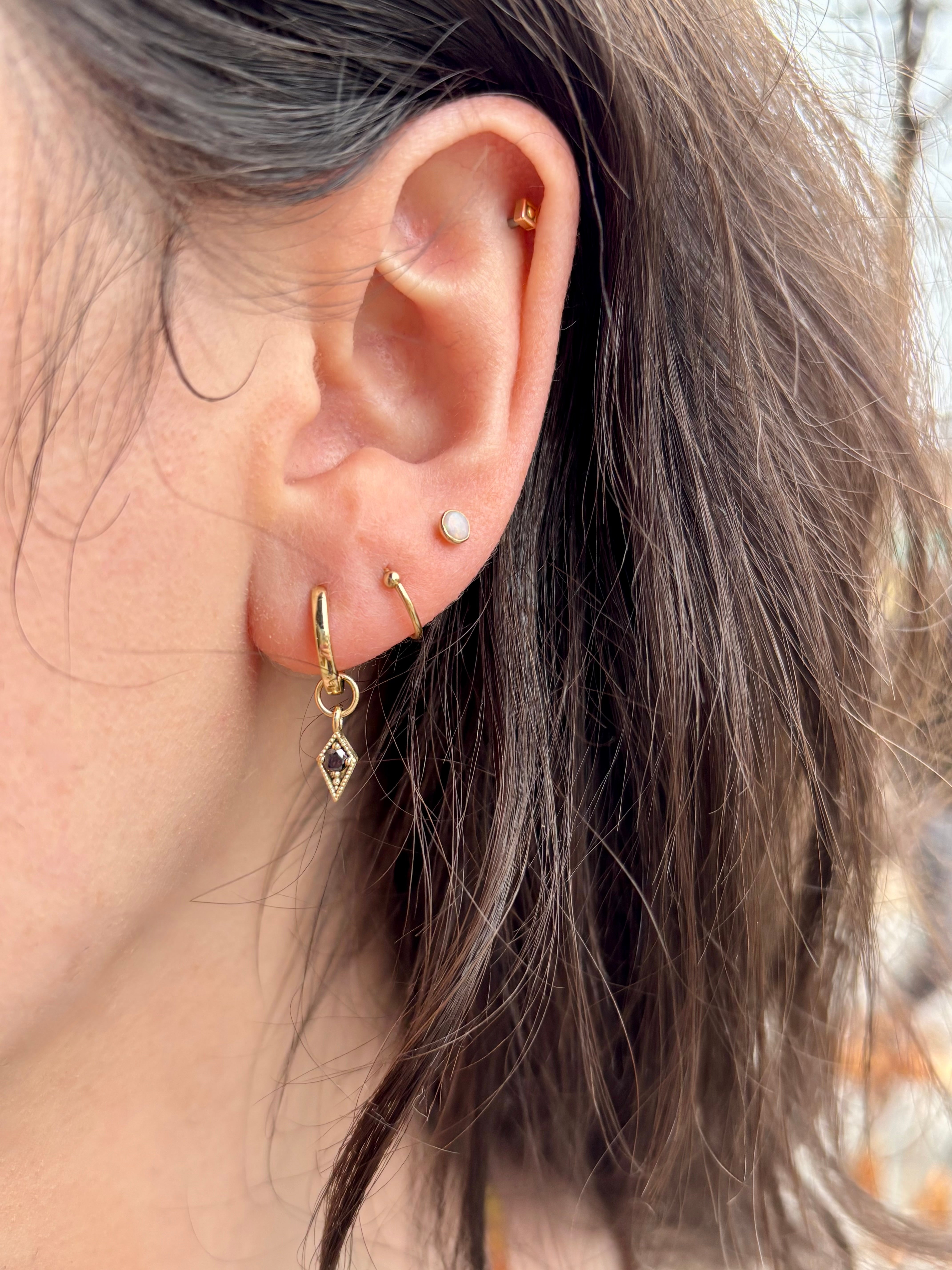 Woman wearing Asheville jeweler STEPHANIE ELLIS Black Diamond Charm Hoops in 14K Yellow Gold