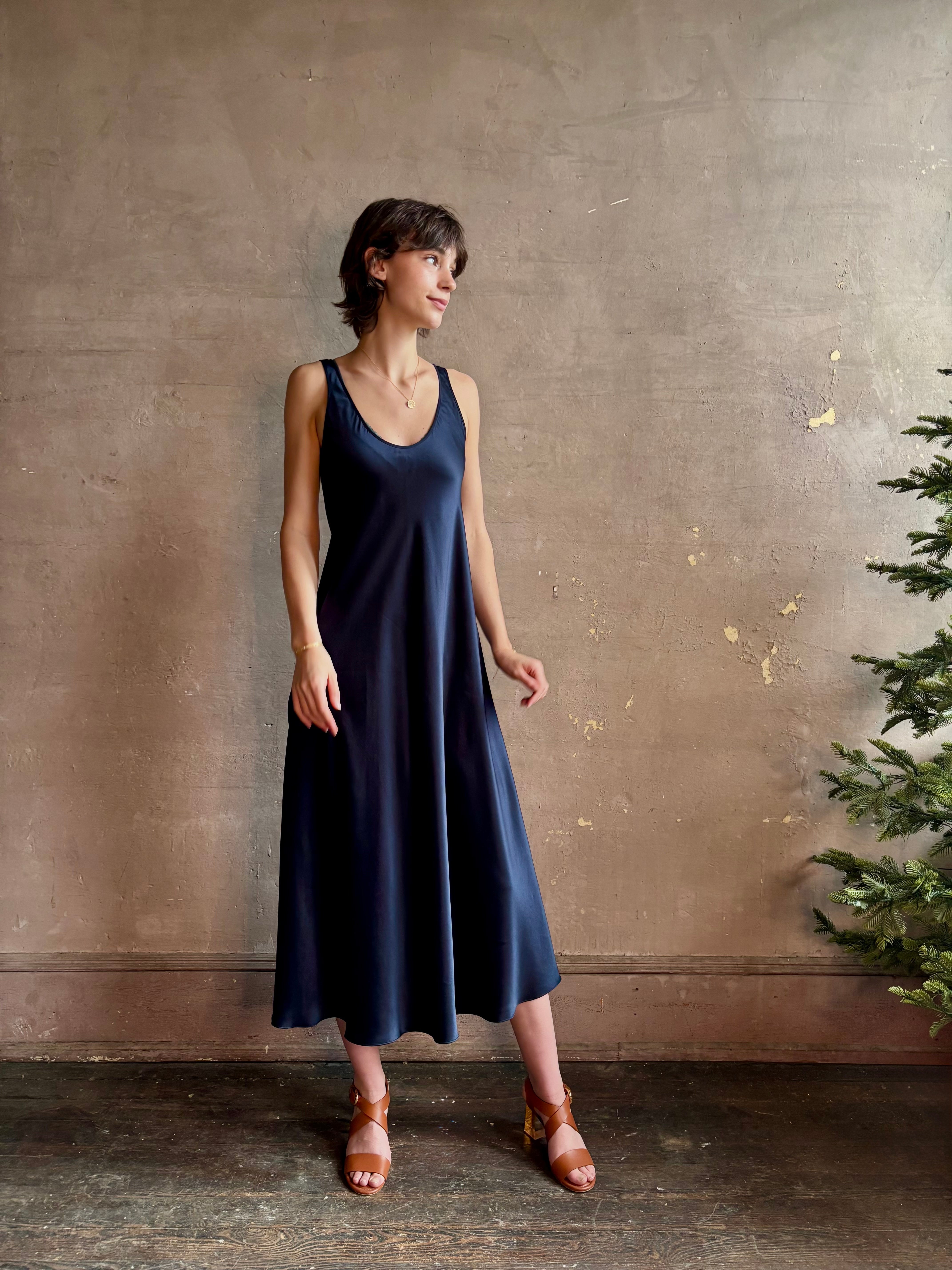 Womanl wearing luxury Sablyn navy blue silk charmeuse sleeveless slip maxi dress with scoop neck and low back