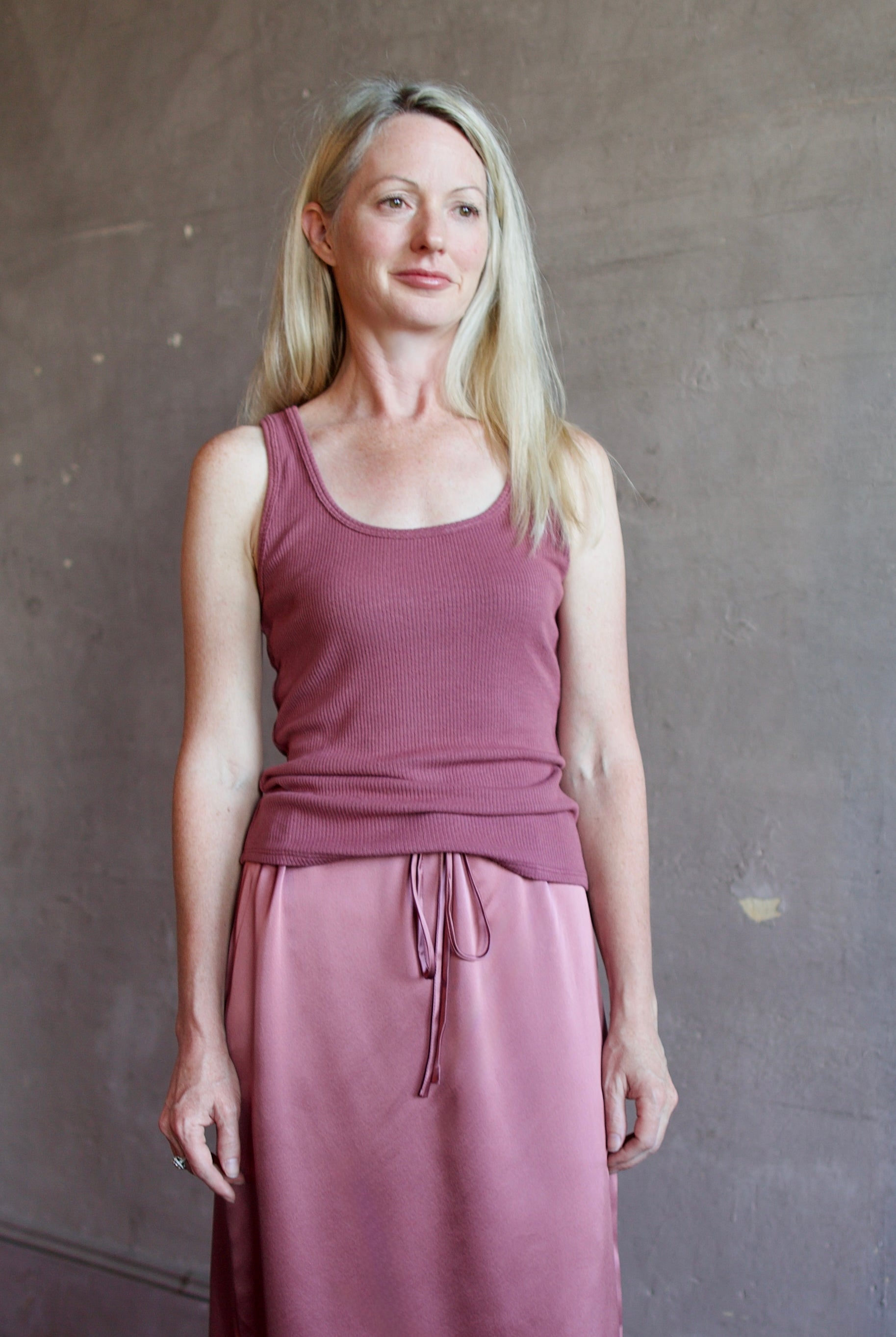Model wearing luxury brand Sablyn layering coco scoop neck tank top in rich mauve colorway with premium ribbed texture fabric