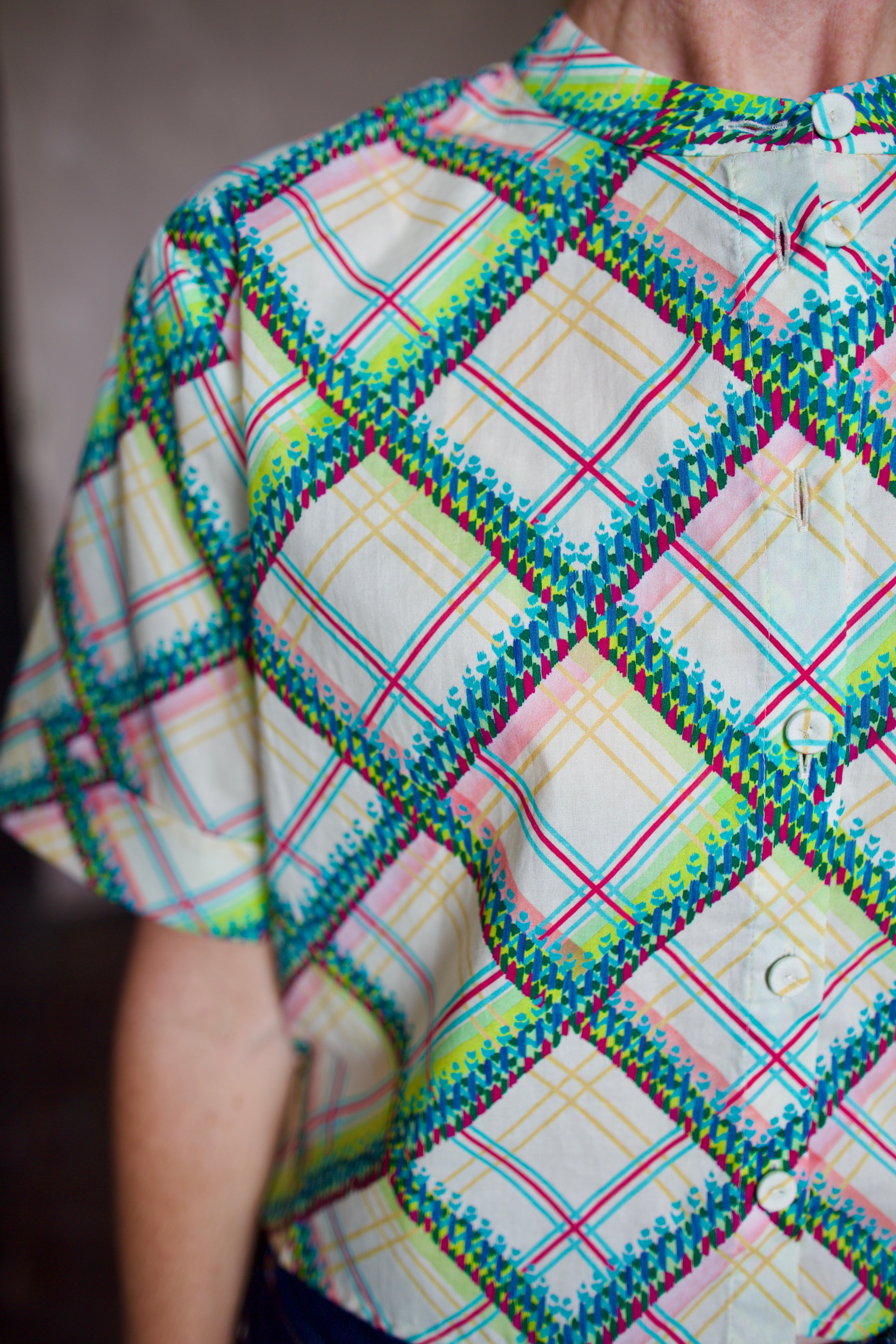 Model wearing the Saloni Jude short sleeve plaid button up crop top and AGOLDE dark denim