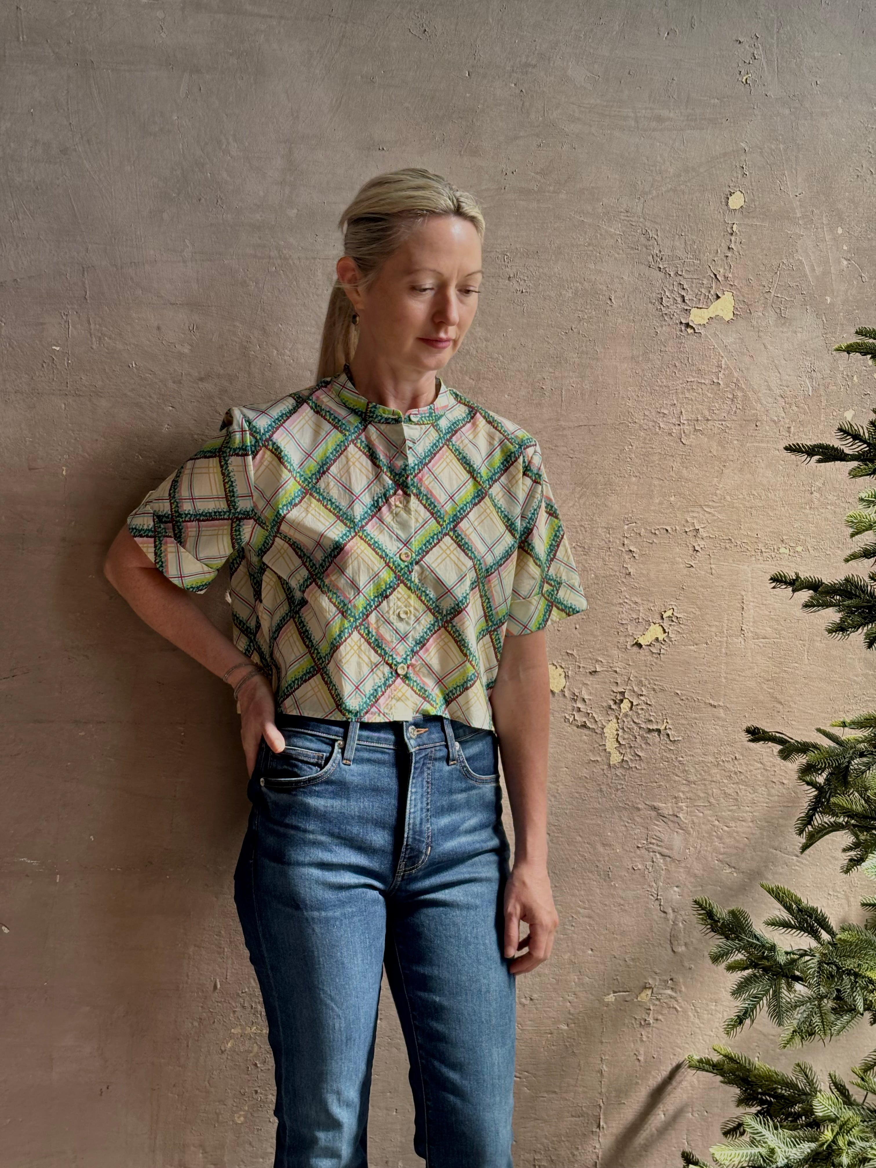 Mature woman wearing the Saloni Jude-B short sleeve plaid button up crop top crafted in cotton with happy diagonal green plaid expertly aligned pattern