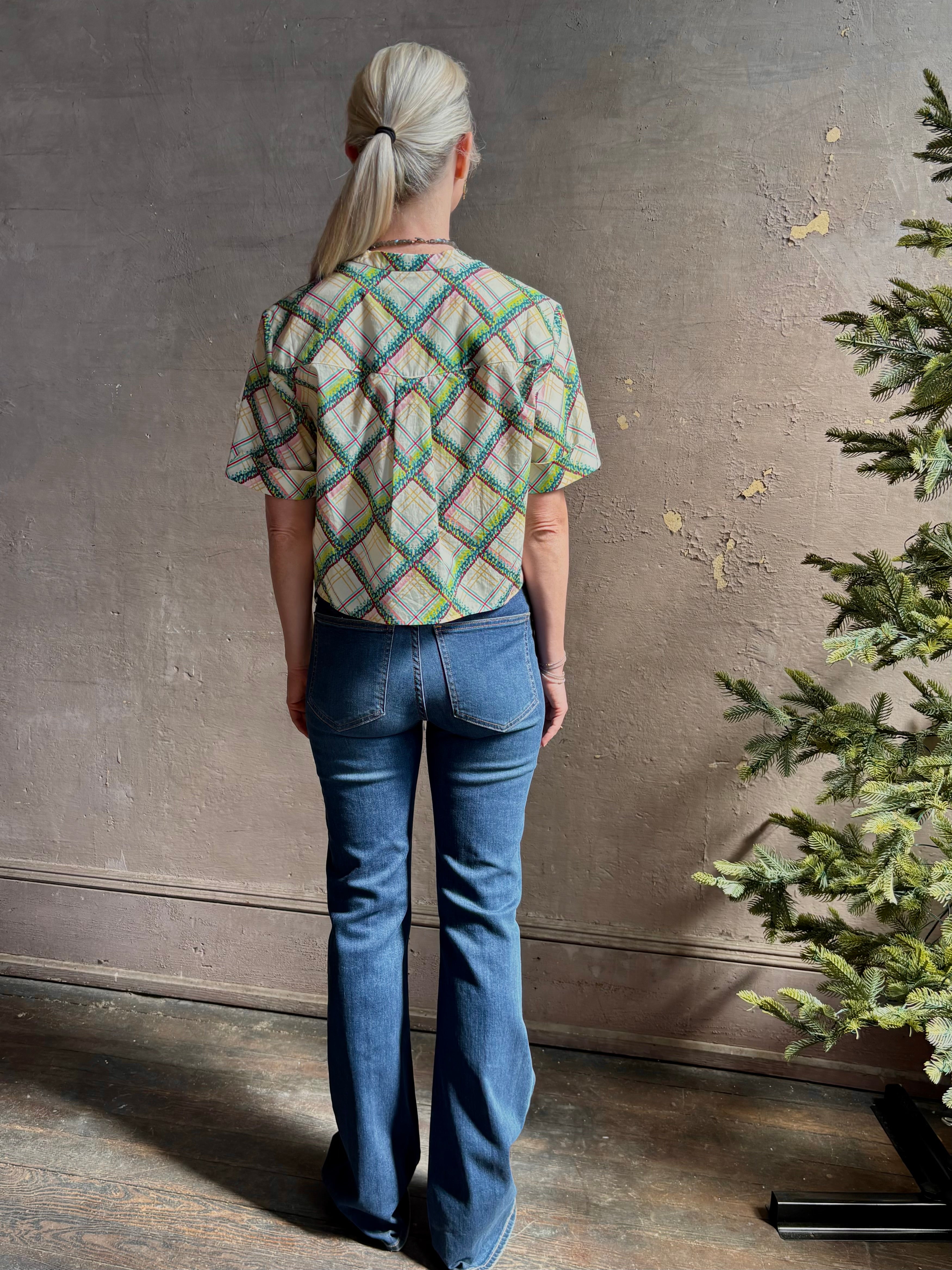 Mature woman wearing the Saloni Jude-B short sleeve plaid button up crop top crafted in cotton with happy diagonal green plaid expertly aligned pattern