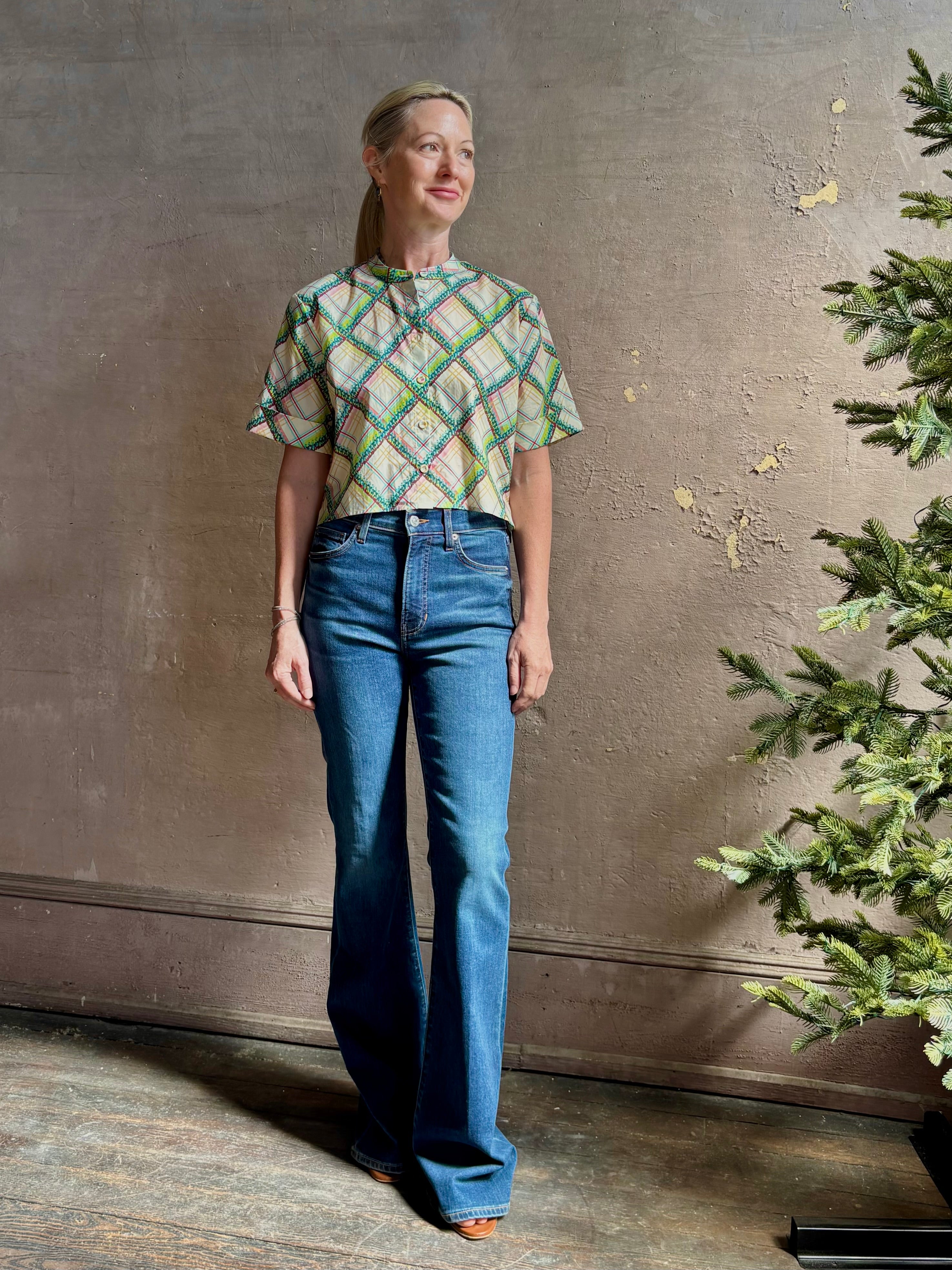 Mature woman wearing the Saloni Jude-B short sleeve plaid button up crop top crafted in cotton with happy diagonal green plaid expertly aligned pattern