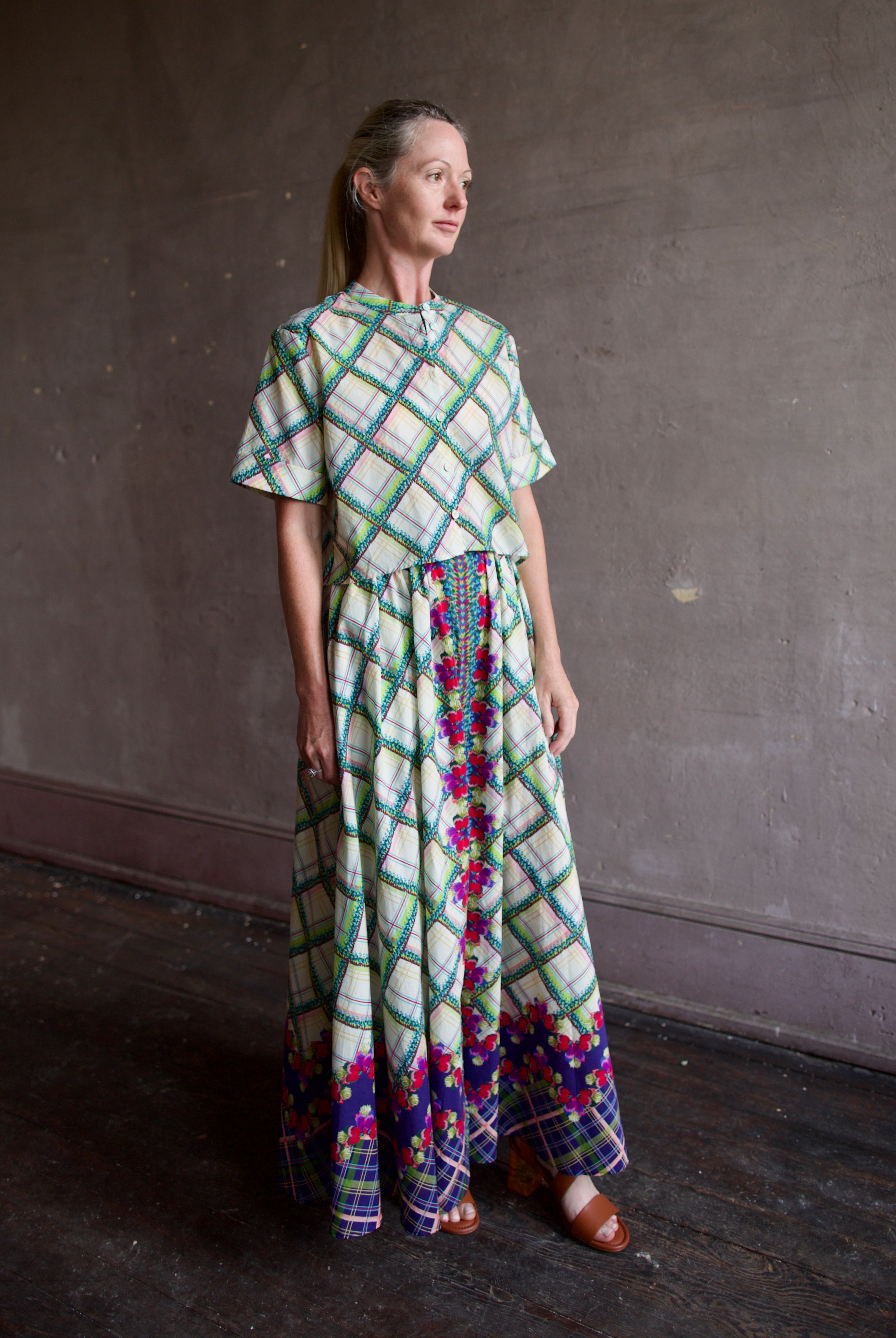 Model in Saloni Judi plaid maxi skirt with matching belt and trimmed in pansies worn with matching Jude top