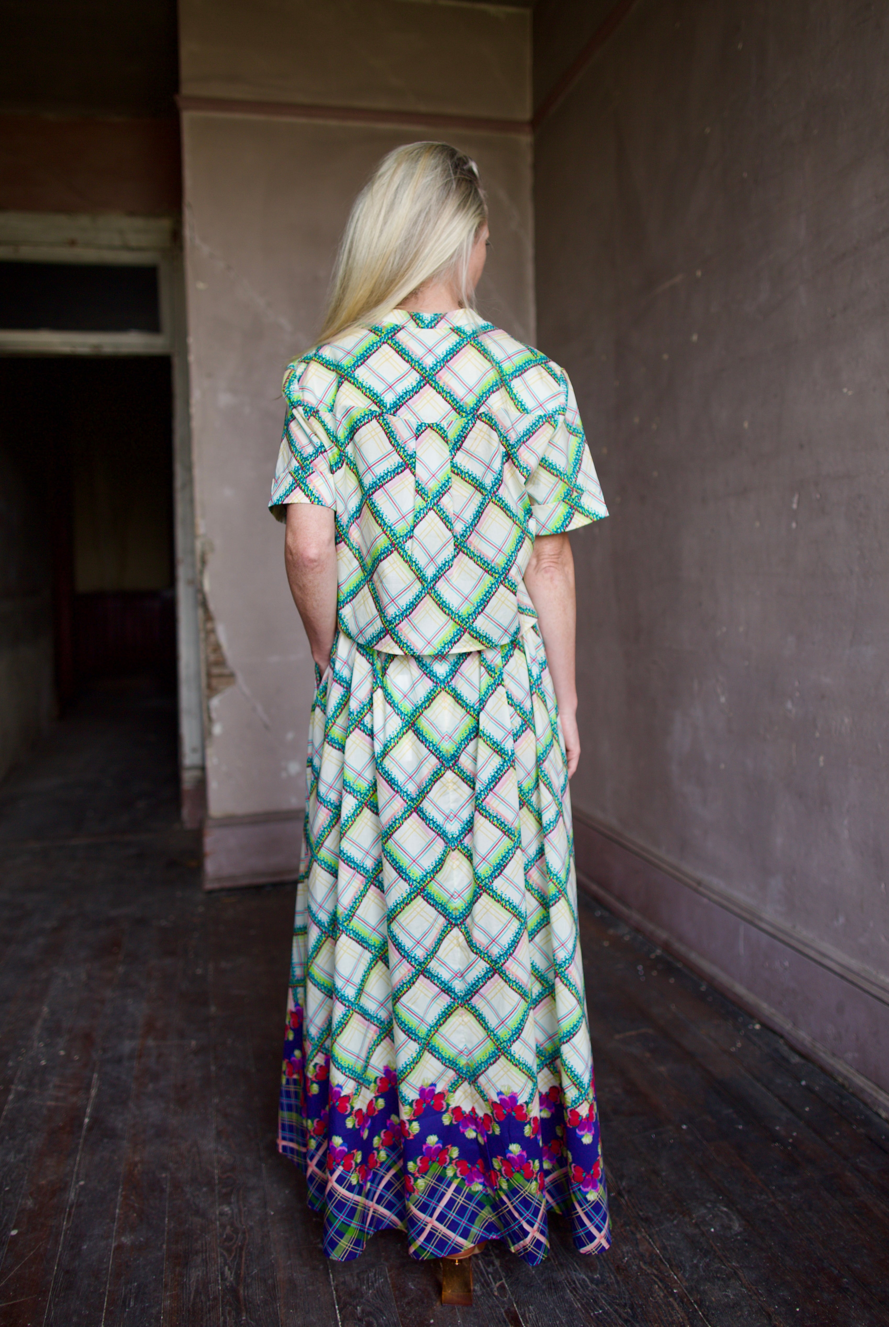 Model in Saloni Judi plaid maxi skirt with matching belt and trimmed in pansies worn with matching Jude top