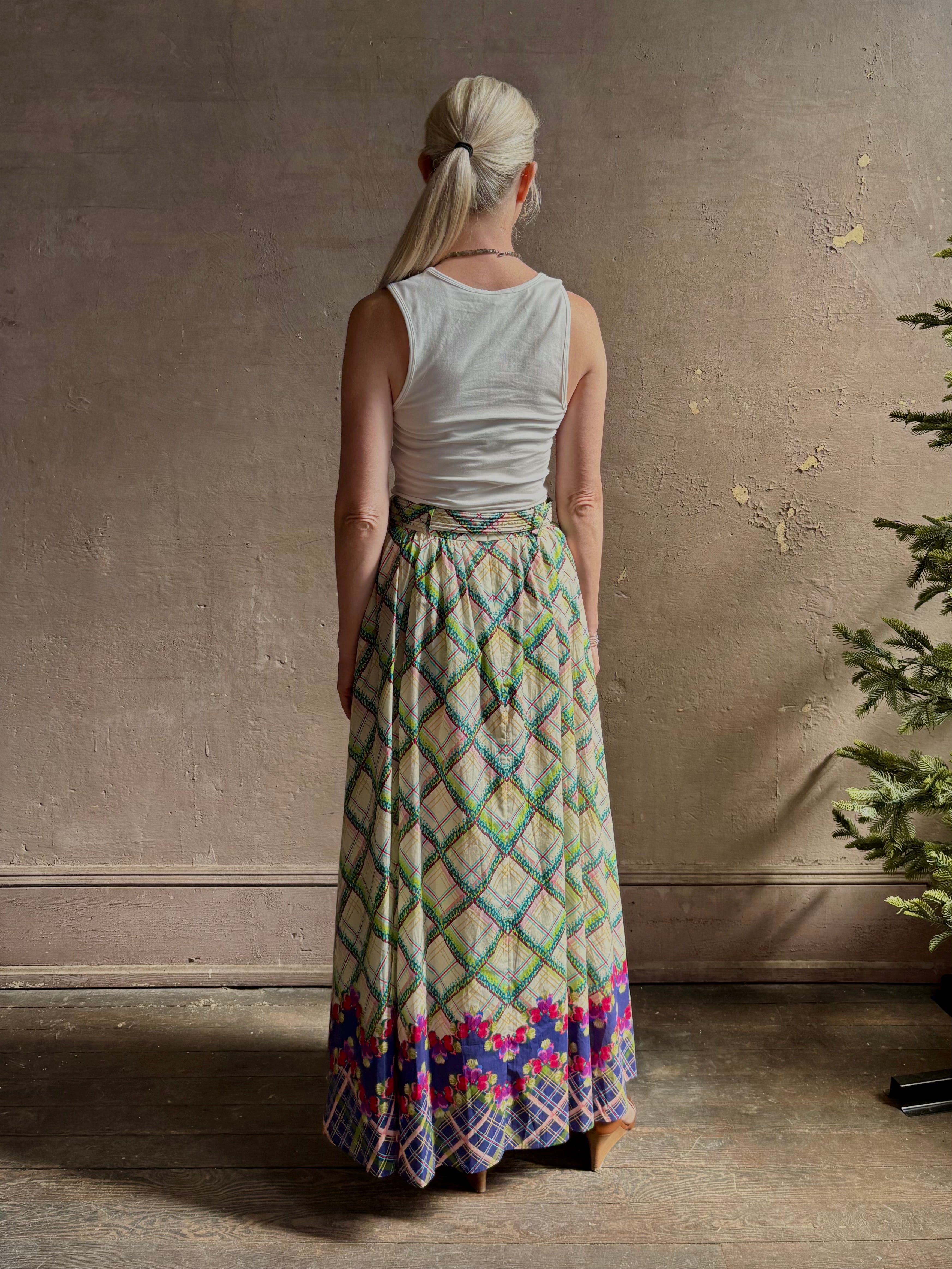 Mature woman reviewing Saloni Judi maxi plaid skirt with matching belt. This cotton A-line skirt is trimmed in pansies down front and bottom with front opening for additional ventilation