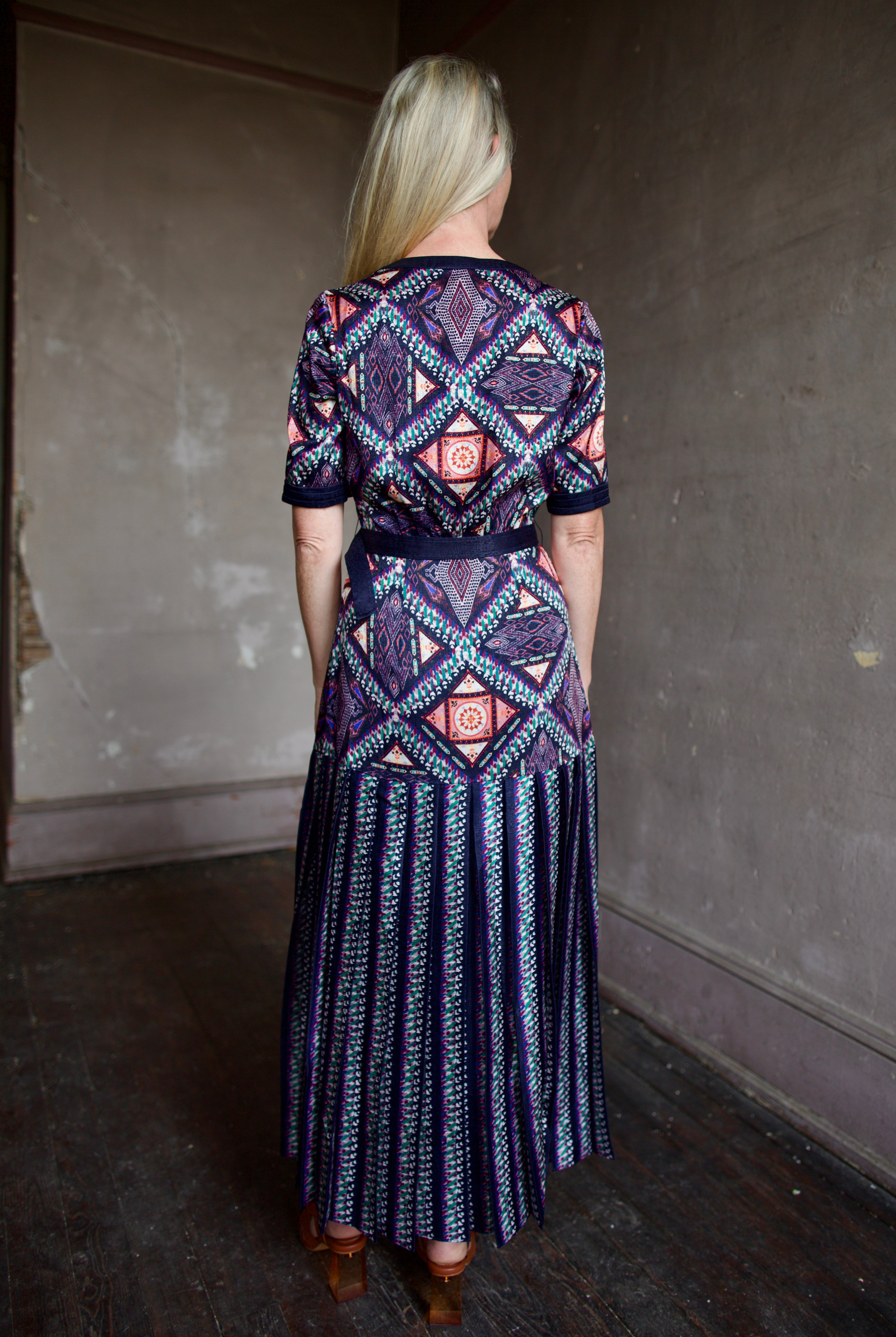 Model wearing timeless short sleeve Saloni Lea drop waist shirt dress in ikat compass print and pleated