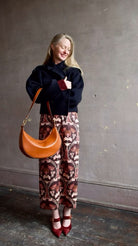 Image of woman wearing Cara Cara Blaze Skirt in Arcada Chocolate cotton-spandex construction with elegant Morris floral print, raffia belt, and straight hem