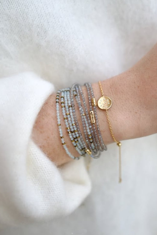 Image of woman wearing everyday luxury Anne Sportun bracelet stack with natural stones hand-hammered textures and brilliant diamond accents