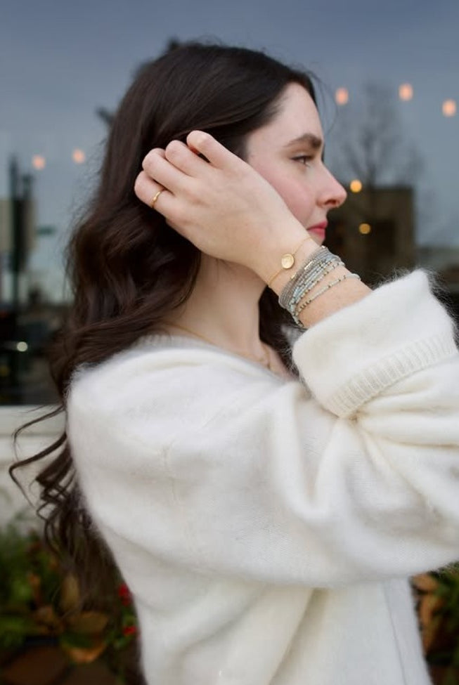 Image of woman wearing everyday luxury Anne Sportun bracelet stack with natural stones hand-hammered textures and brilliant diamond accents