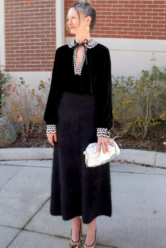 Mature model wearing the Italian leather Mini Cloud clutch by high-end designer Mansur Gavriel in metallic silver