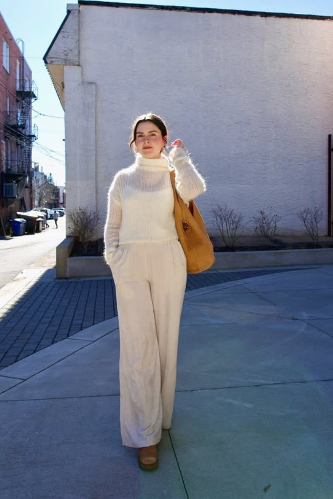 Model wearing luxury Italian leather large hobo by designer Mansur Gavriel  with v-detail handle in camel color