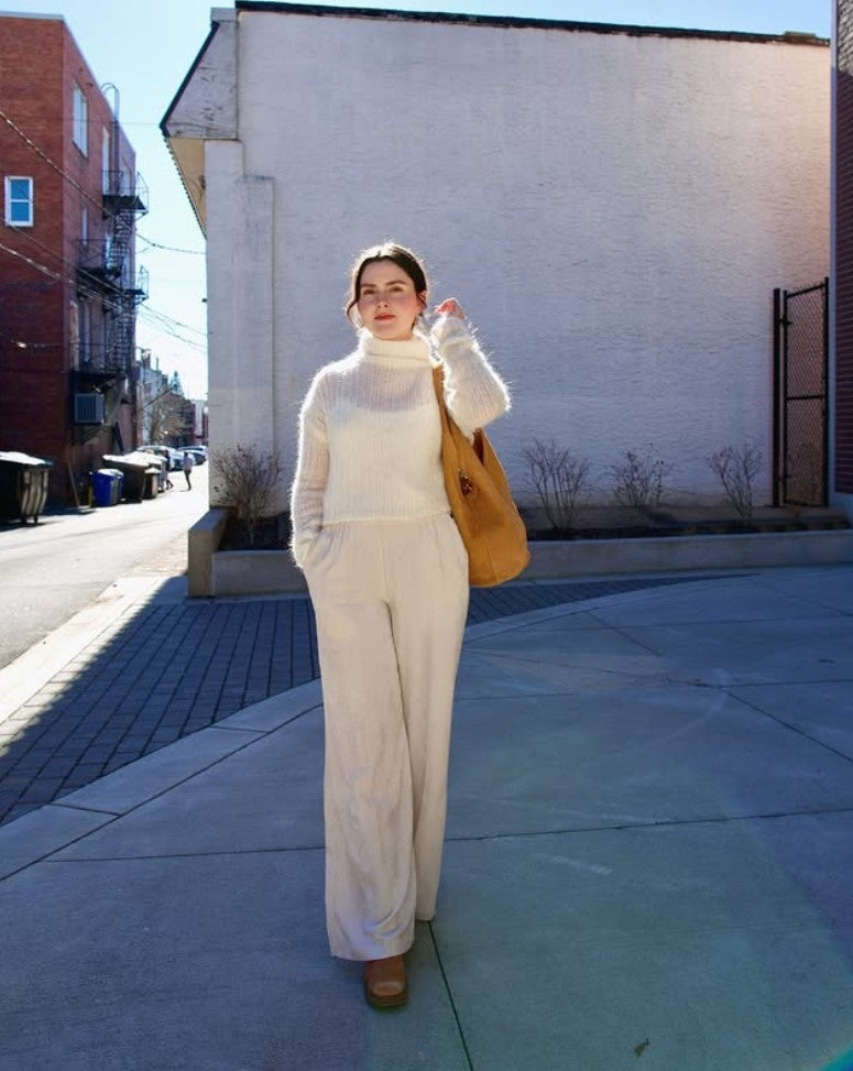 Model wearing luxury Italian leather large hobo by designer Mansur Gavriel with v-detail handle in camel color
