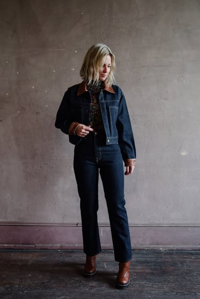 Mature model wearing designer denim jean by Ulla Johnson,Louis Vuitton boots and matching denim and leather jacket