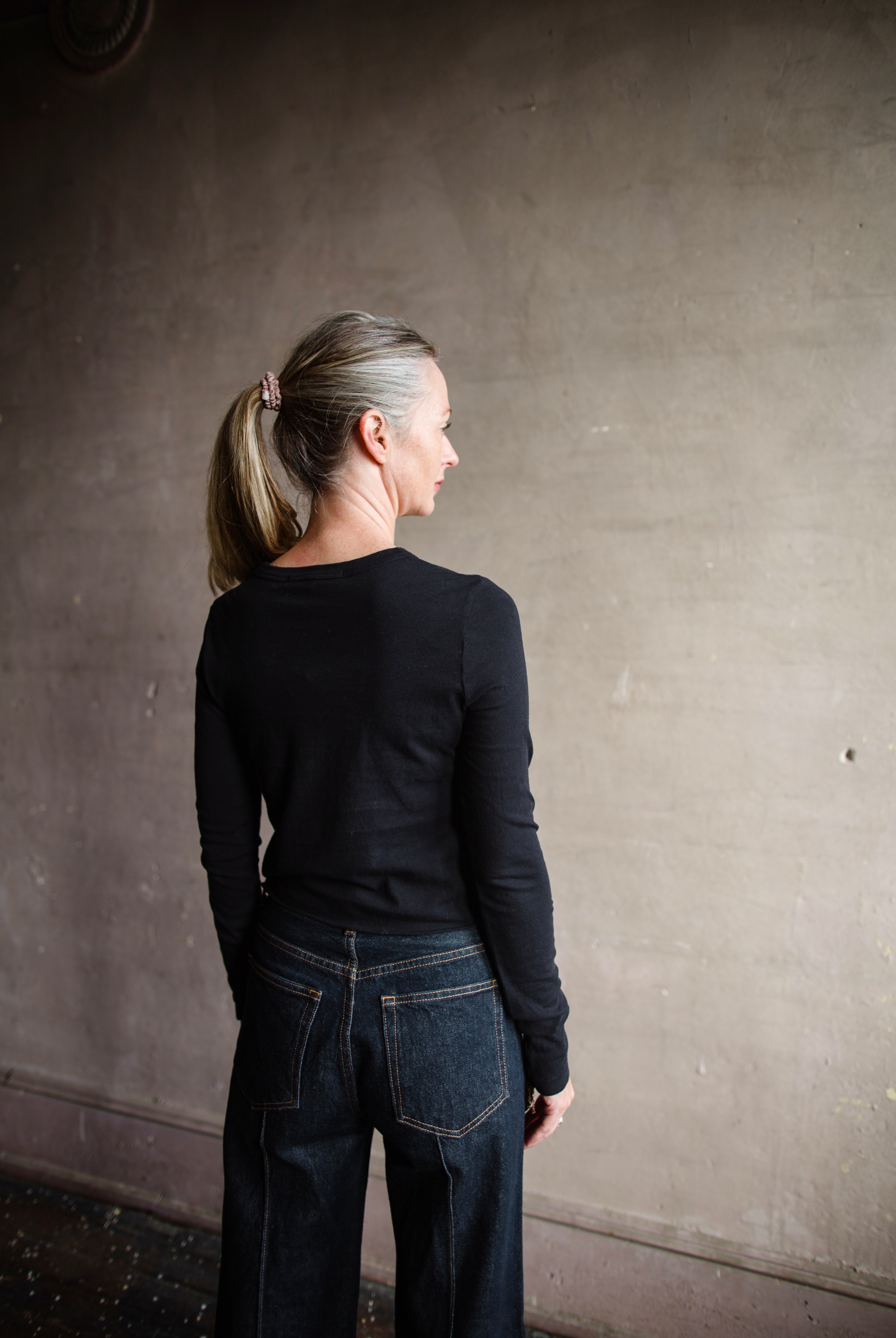 Image featuring a woman wearing the Slvrlake The Baby Long Sleeve Tee by Slvrlake baby tee with a crew neckline, long sleeves and a cropped fit fabricated in cotton.