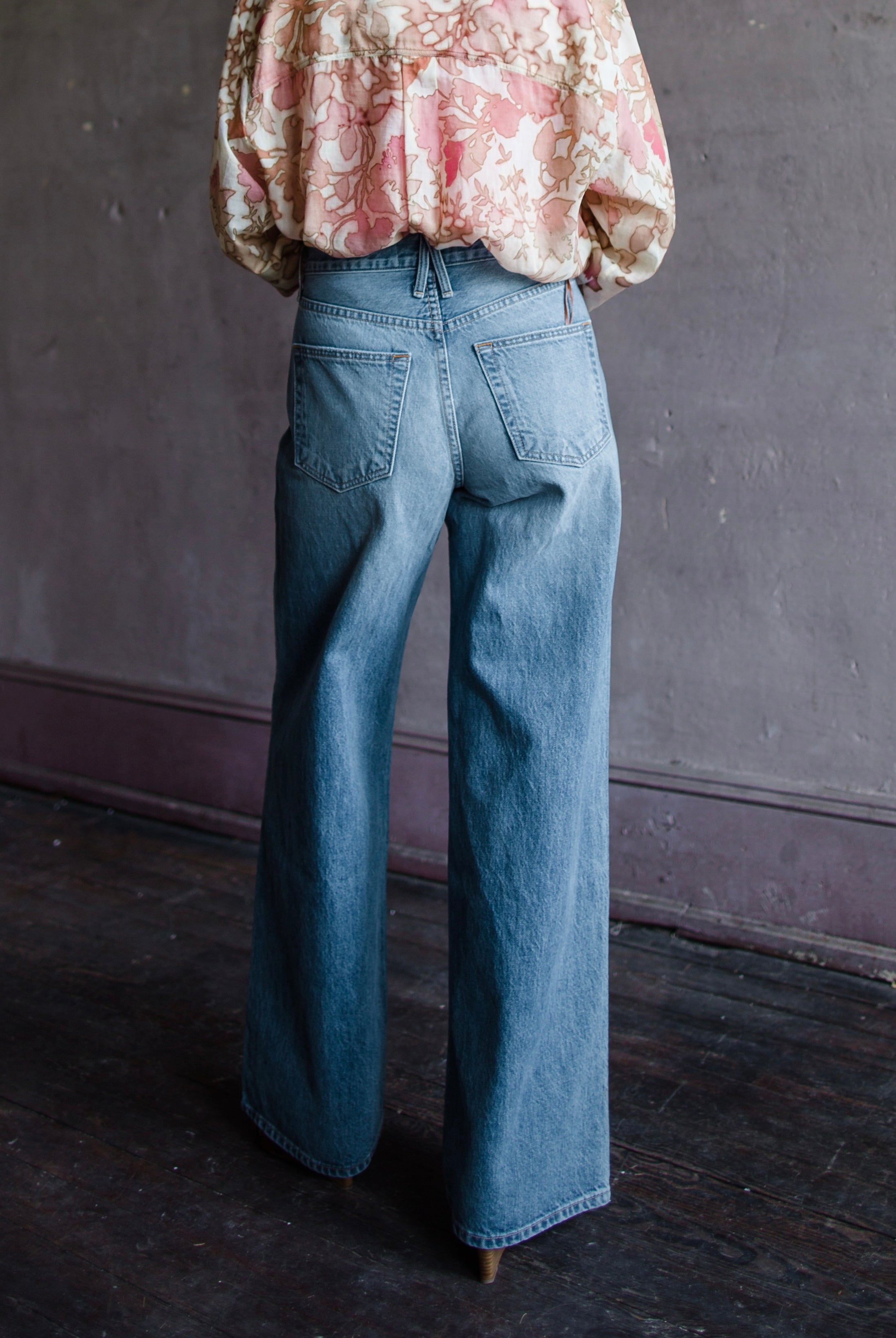 Image featuring a woman wearing the Selena 100% rigid cotton jeans by Slvrlake with a mid rise, full length wide leg.
