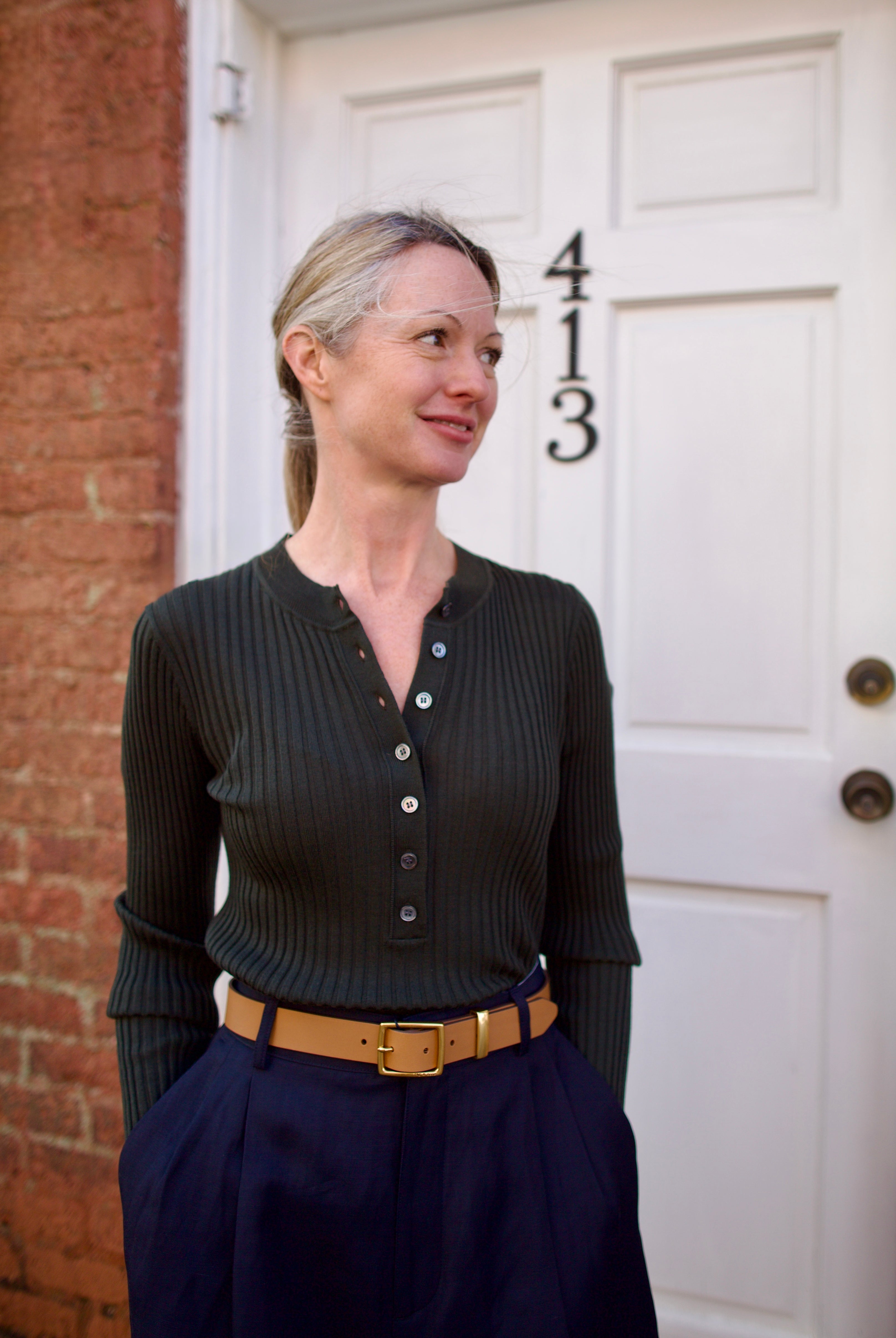 Image of a woman wearing the Soeur Buffalo Ribbed Henley, Rag and Bone Belt and Apiece Apart Trousers