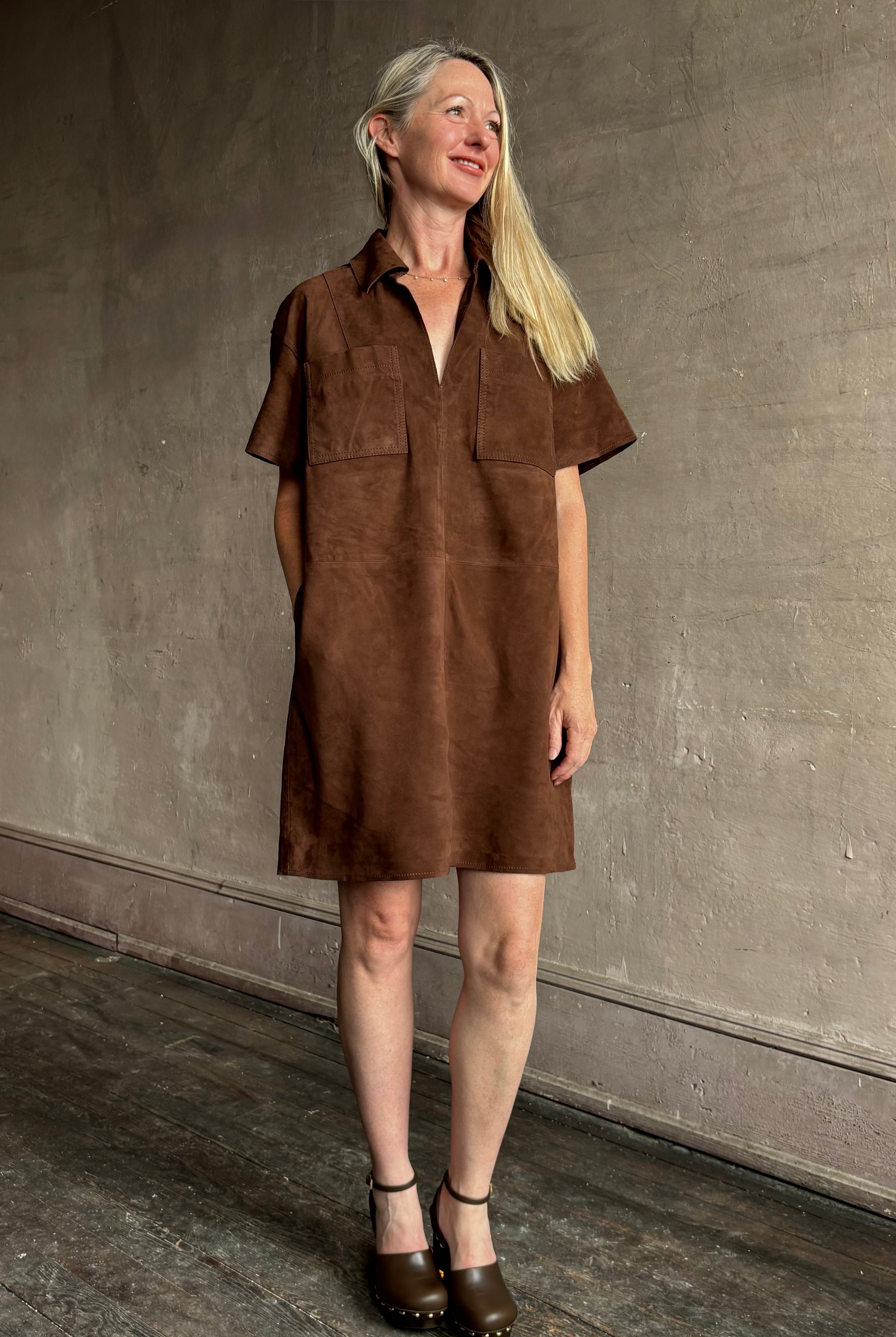 Image of mature woman wearing designer Tanya Taylor chocolate leather shift dress with above-knee hemline and hidden pockets
