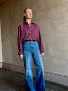 Image of mature woman wearing Trovata Blake Oversized premium cotton button down long sleeve Shirt in Mulled Wine Plaid