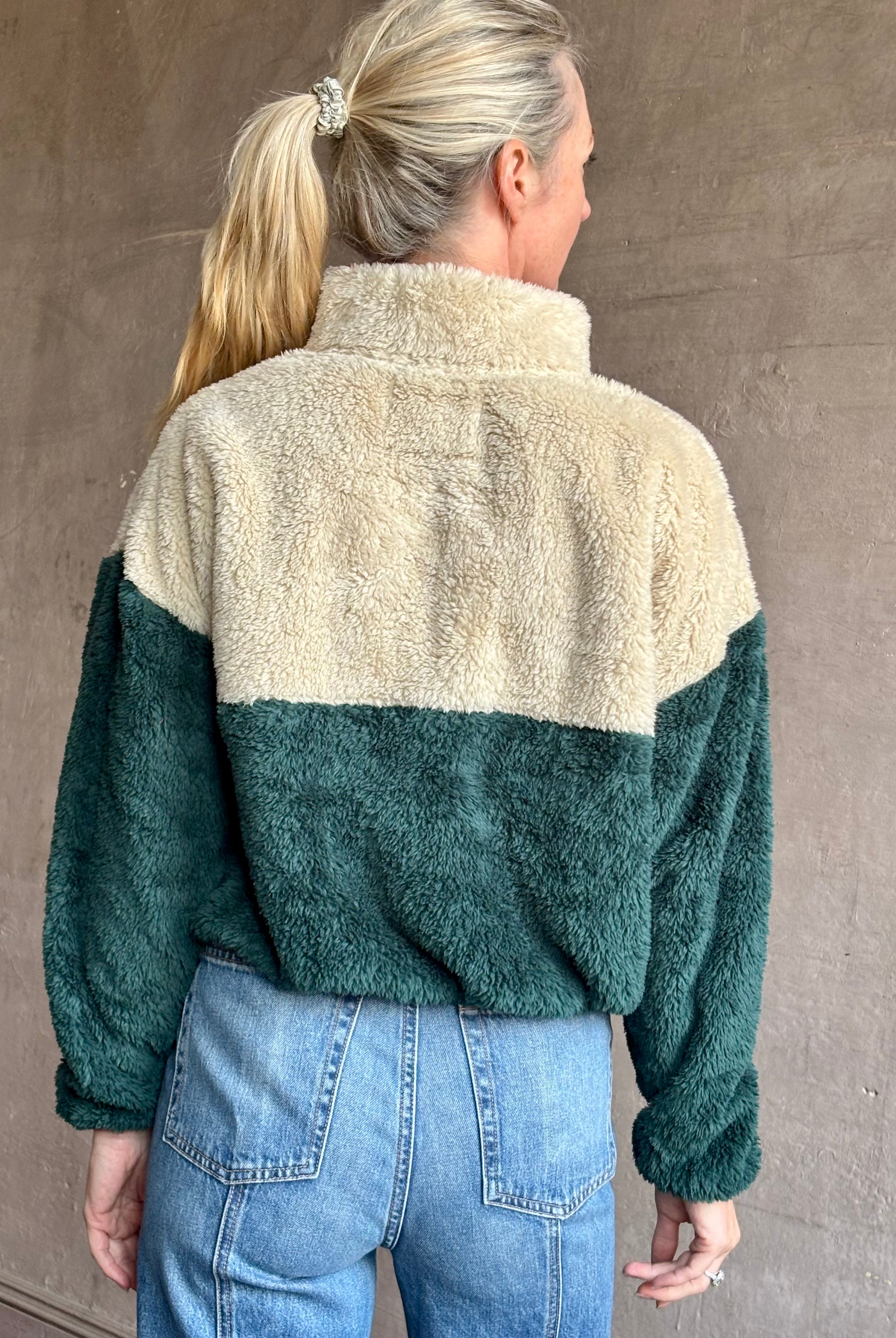 Image of mature woman wearing Trovata Casey premium fleece quarter zip Pullover in Ponderosa green orange and cream colorway