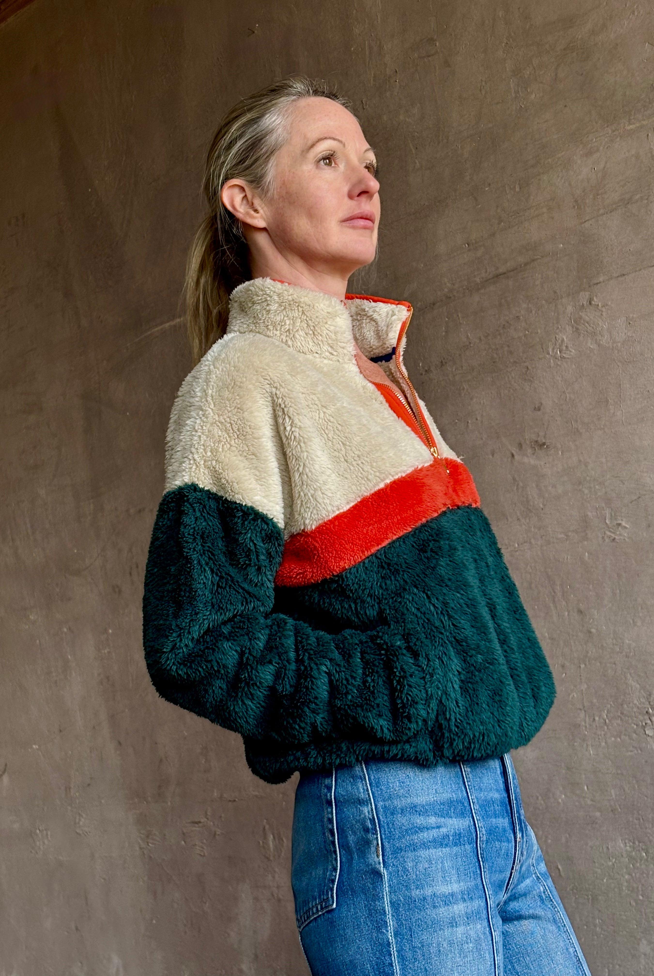 Image of mature woman wearing Trovata Casey premium fleece quarter zip Pullover in Ponderosa green orange and cream colorway