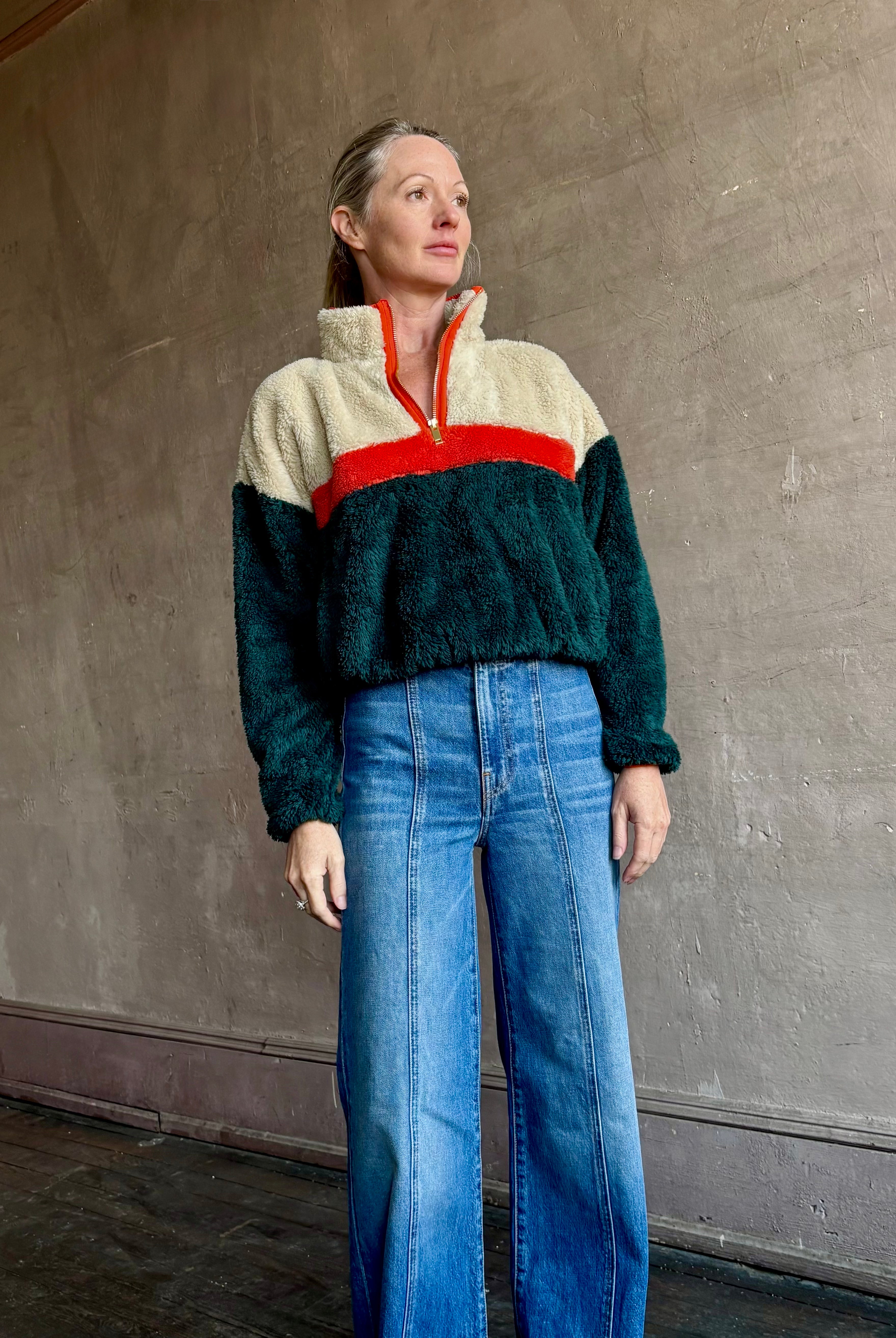 Image of mature woman wearing Trovata Casey premium fleece quarter zip Pullover in Ponderosa green orange and cream colorway