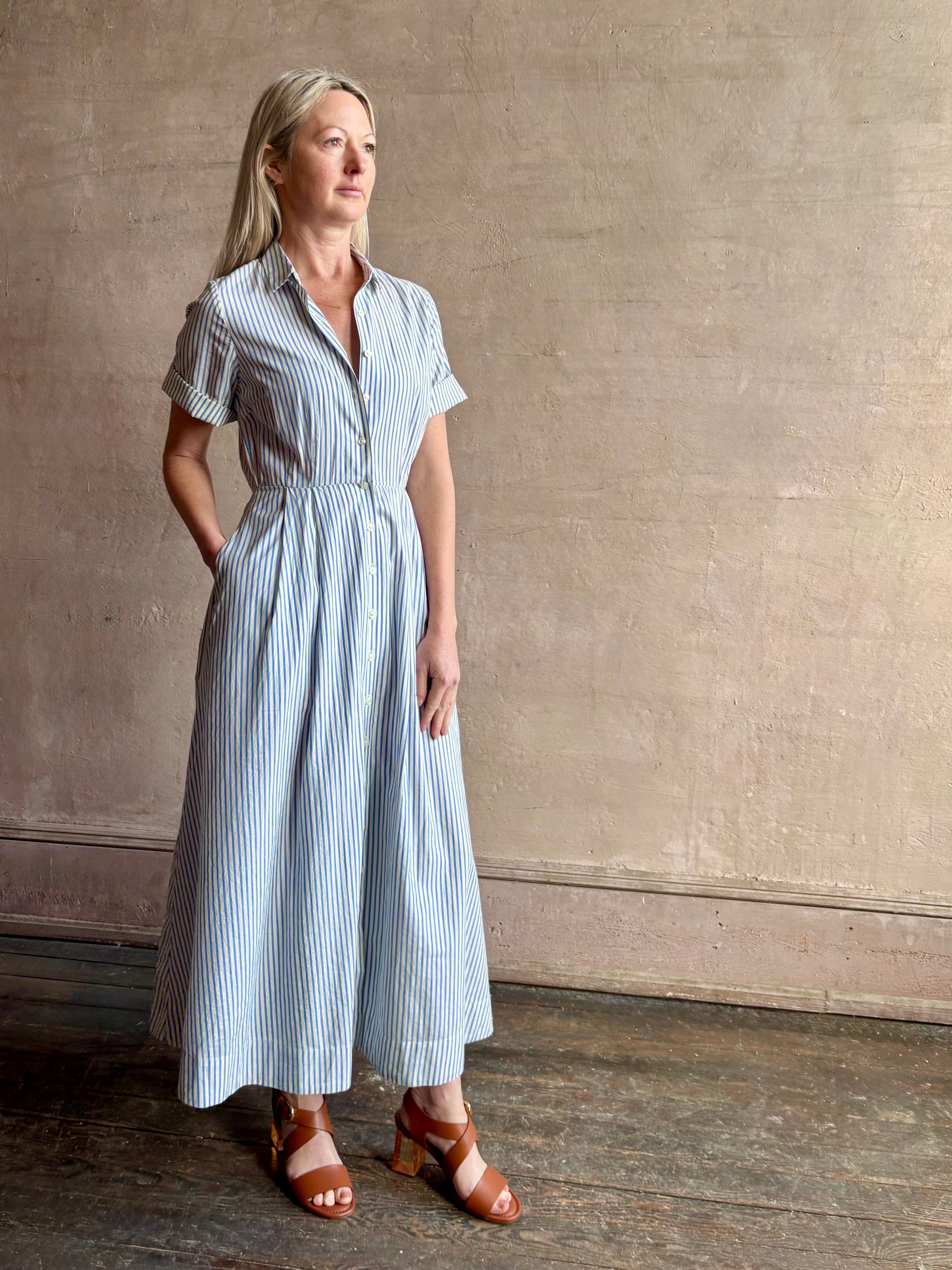 Image of woman wearing timeless TROVATA Aster A-line cotton shirt maxi Dress in Seaside blue and white Stripe with hidden seam pockets
