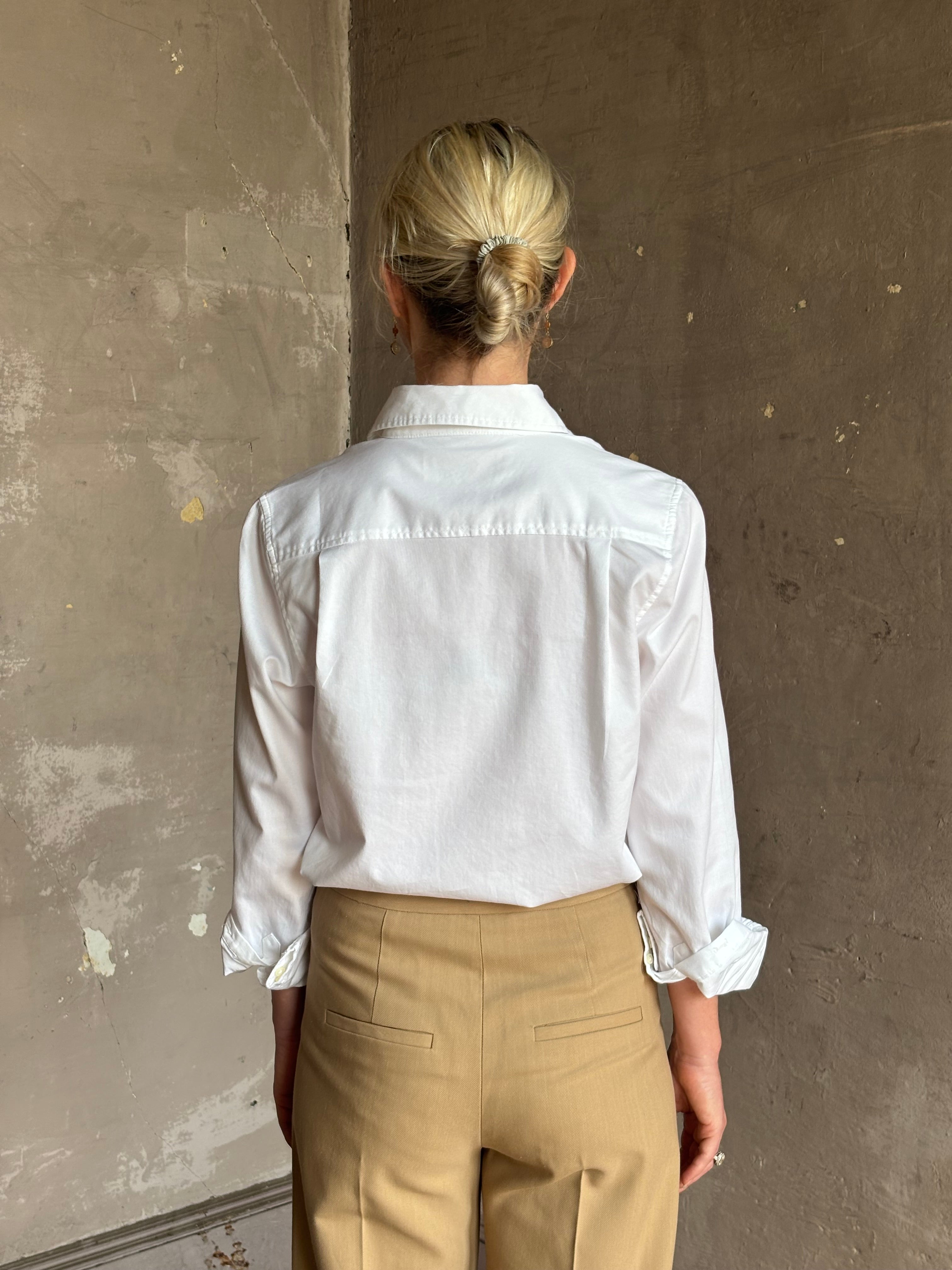 woman wearing white Trovata Justine blouse collared V-neck button-front closure cuffed long sleeves classic silhouette