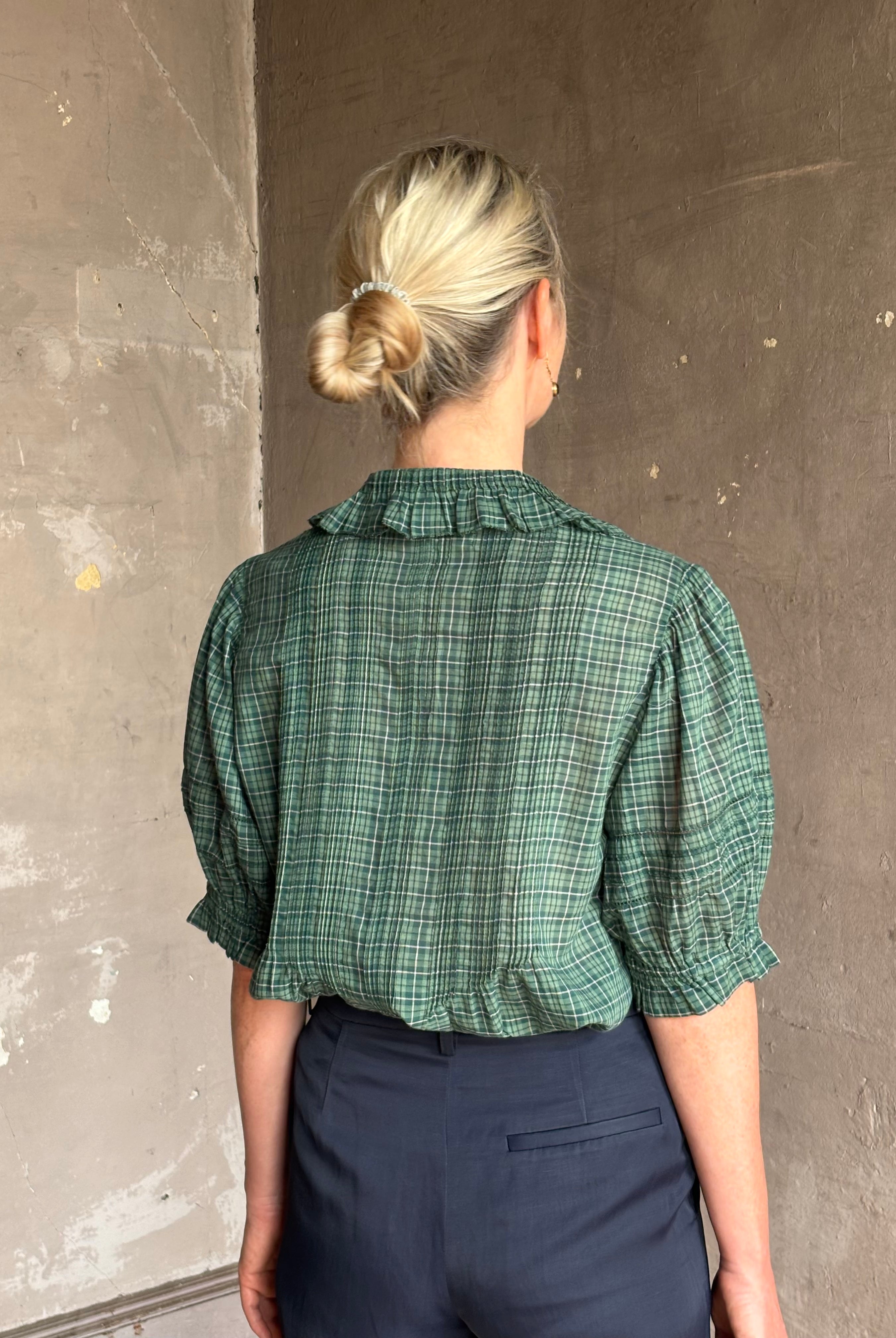 Mature woman wearing Trovata Jess green plaid short sleeve cotton poplin blouse with pintucking and peter pan collar