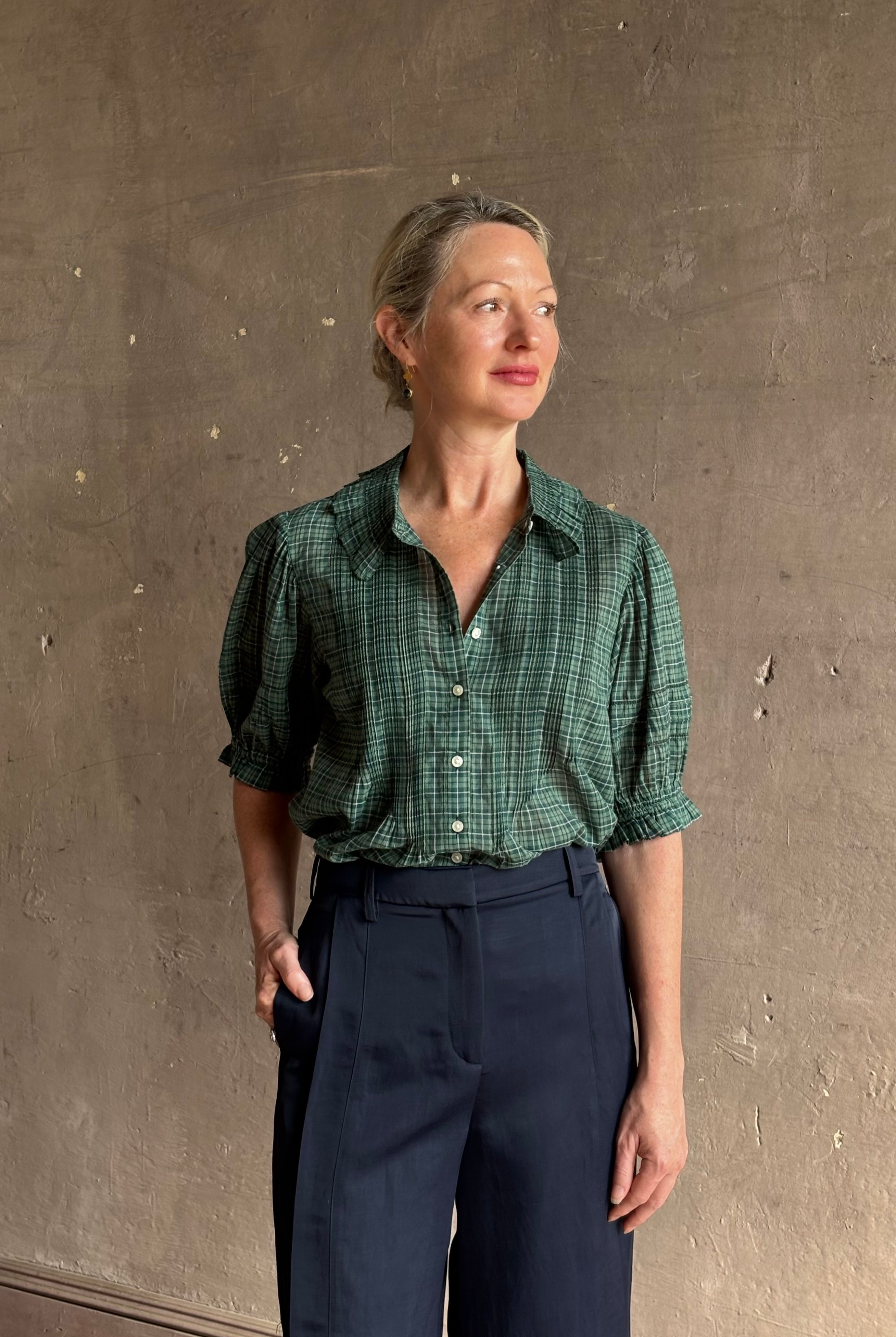 Mature woman wearing Trovata Jess green plaid short sleeve cotton poplin blouse with pintucking and peter pan collar
