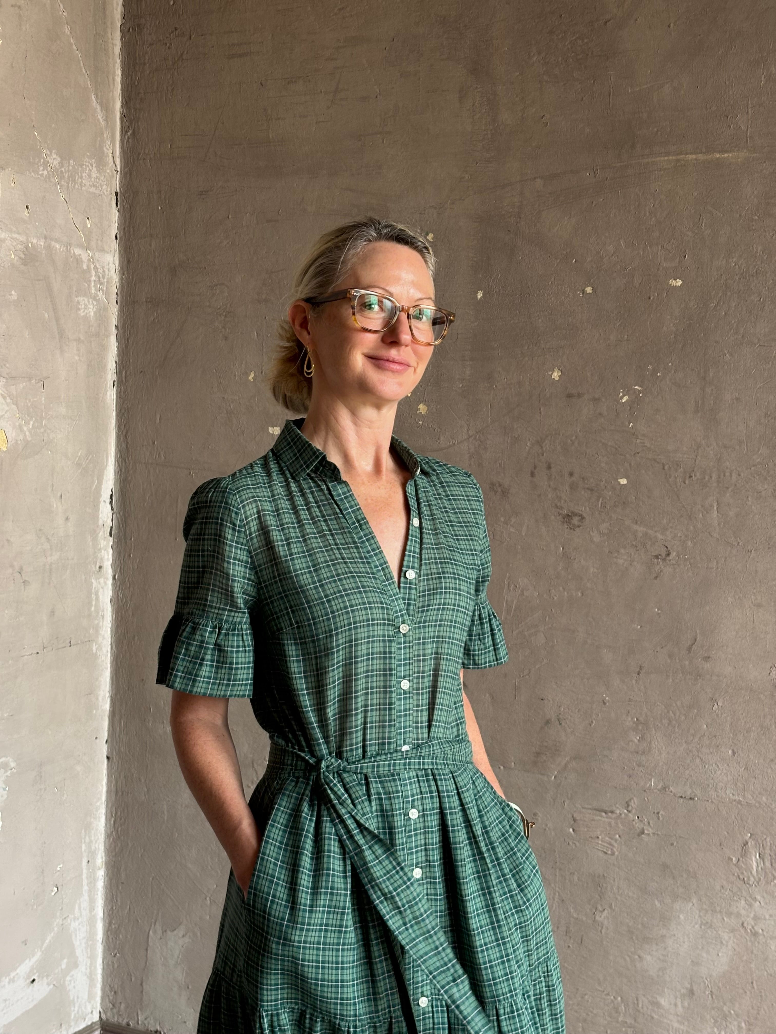 Mature woman wearing Trovata Martine button-up front cotton poplin green plaid maxi dress short sleeves and lightweight